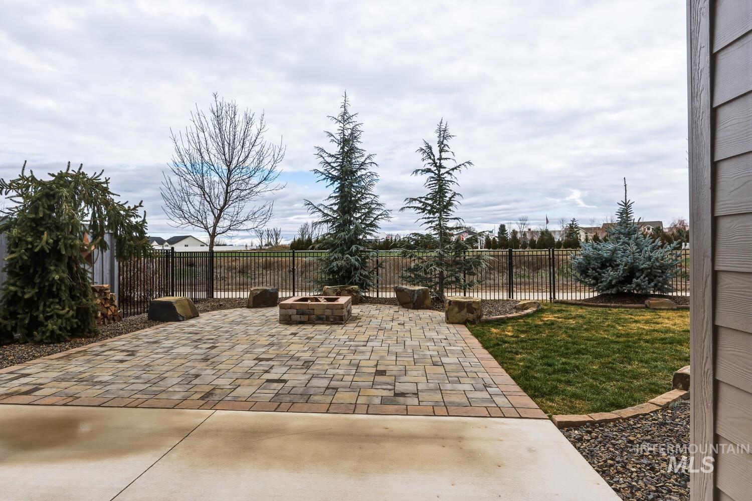 Fenced backyard with a fire pit and a patio