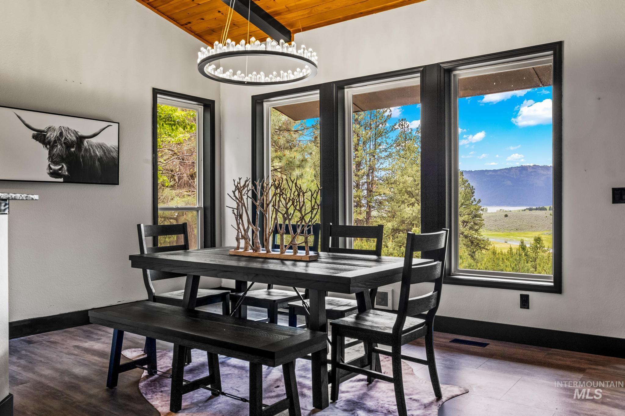 Dining space with wood ceiling, dark wood finished floors, a chandelier, a mountain view, and lofted ceiling