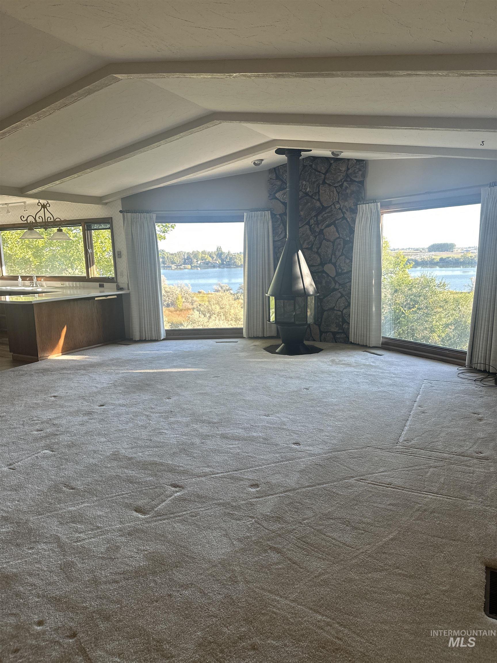 Miscellaneous room featuring a water view, a wood stove, and carpet floors