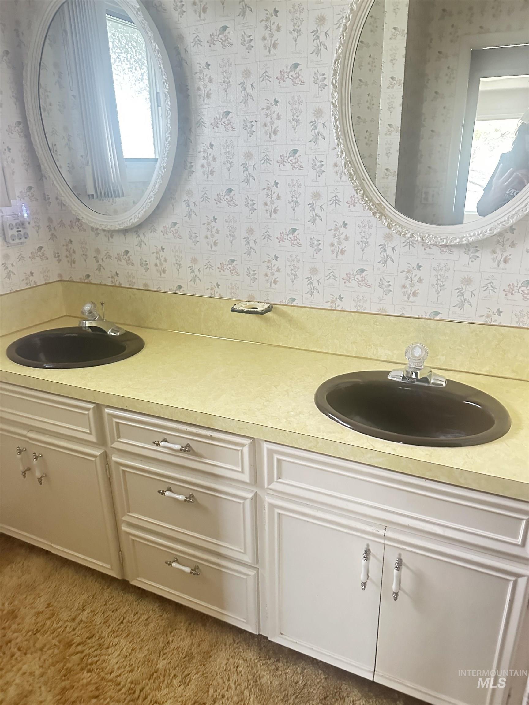 Bathroom with double vanity and wallpapered walls