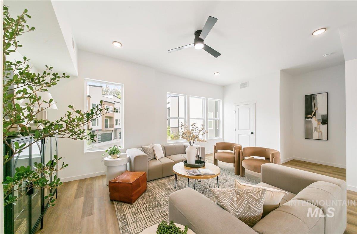 Living area with light wood-style floors, a ceiling fan, and recessed lighting