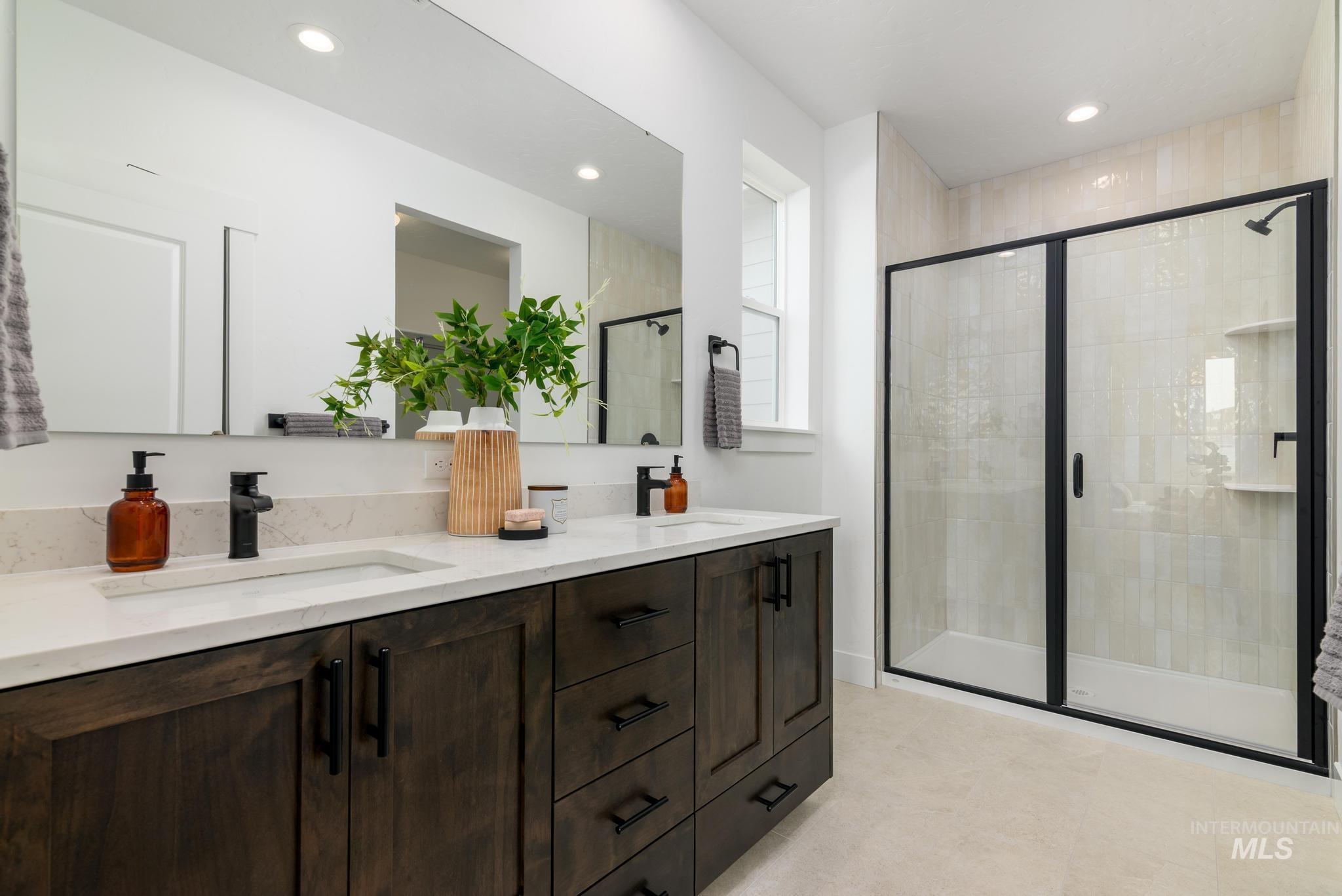 Bathroom with double vanity, a shower stall, recessed lighting, and light tile patterned floors