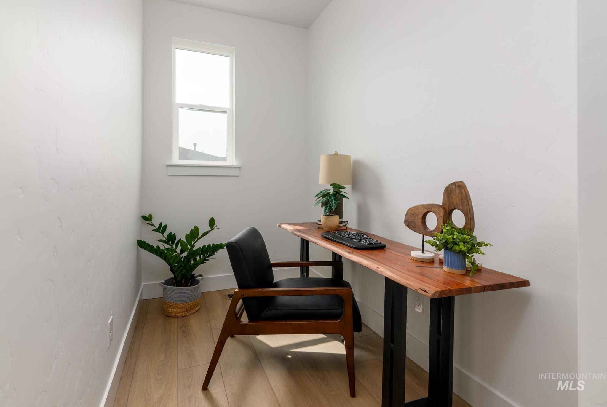 Office area featuring light wood-style flooring and baseboards