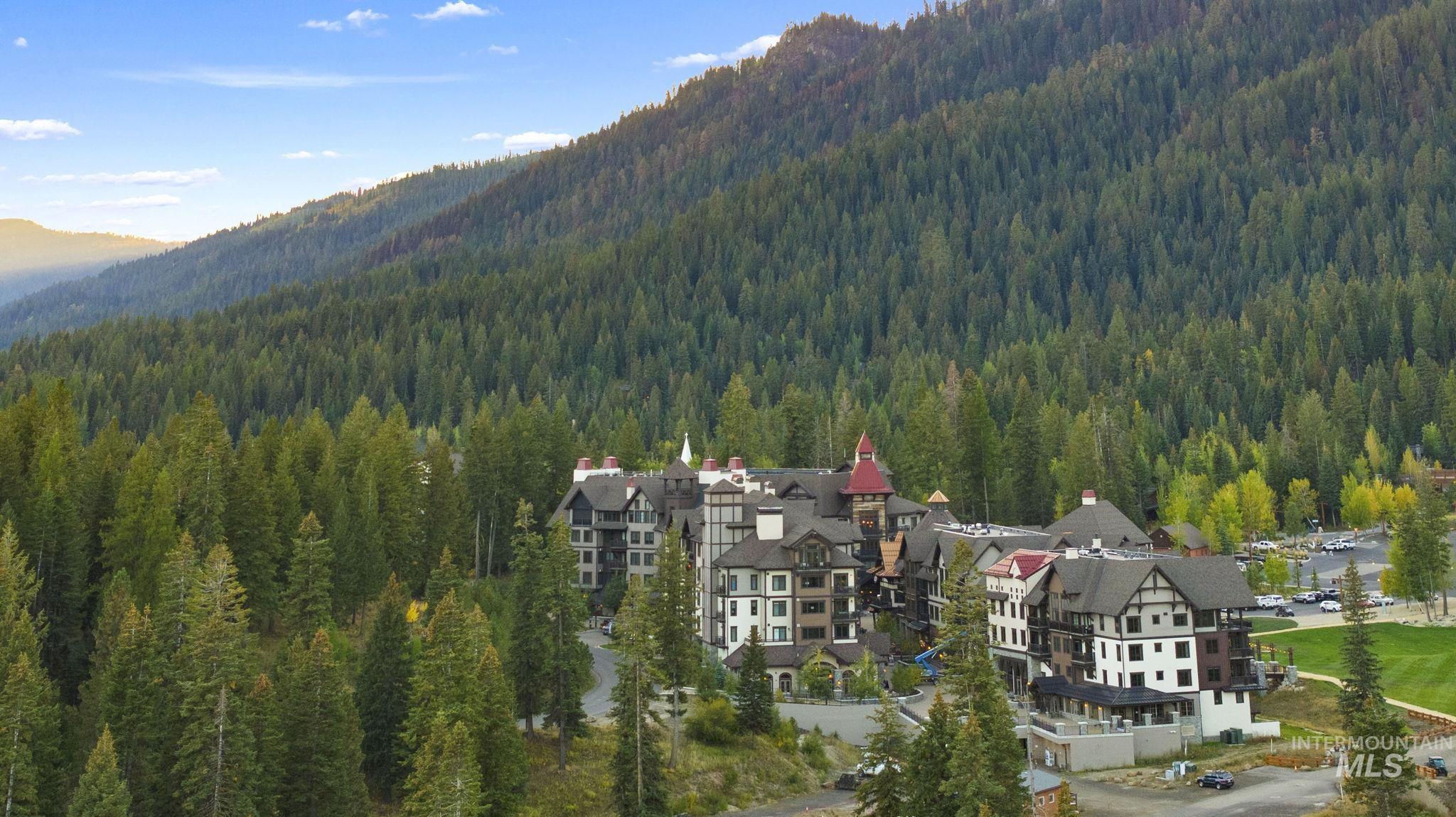 View of mountain backdrop featuring a forest and nearby suburban area
