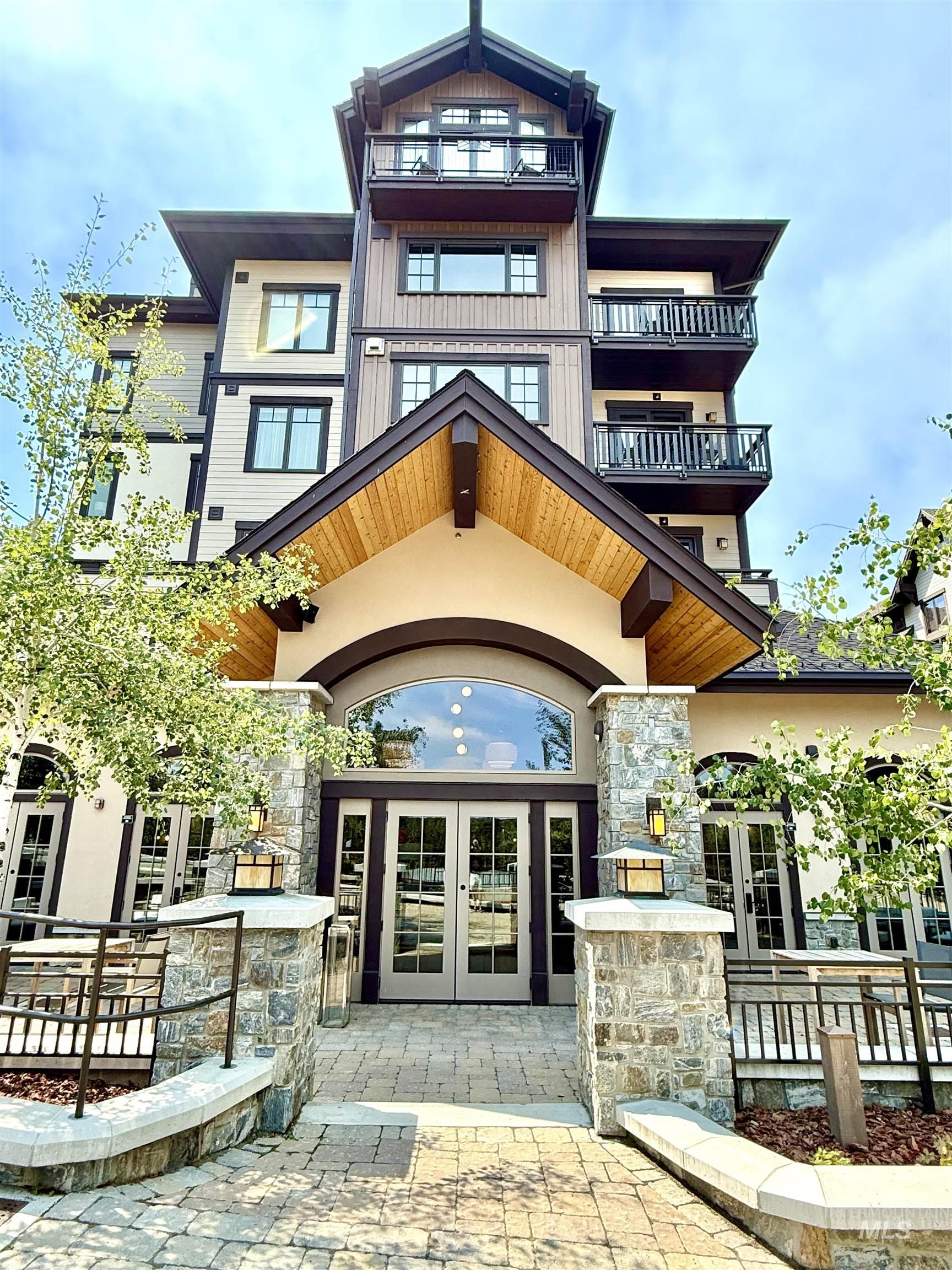 Doorway to property featuring french doors, stone siding, and stucco siding