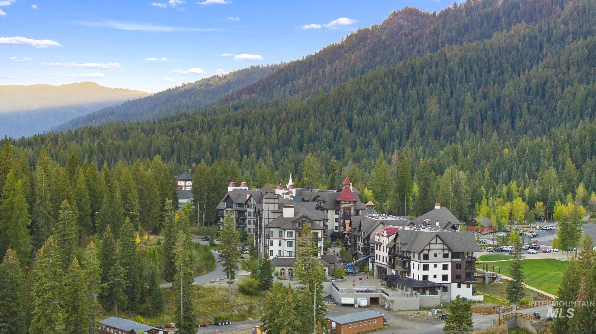 Aerial overview of property's location featuring a mountainous background and nearby suburban area