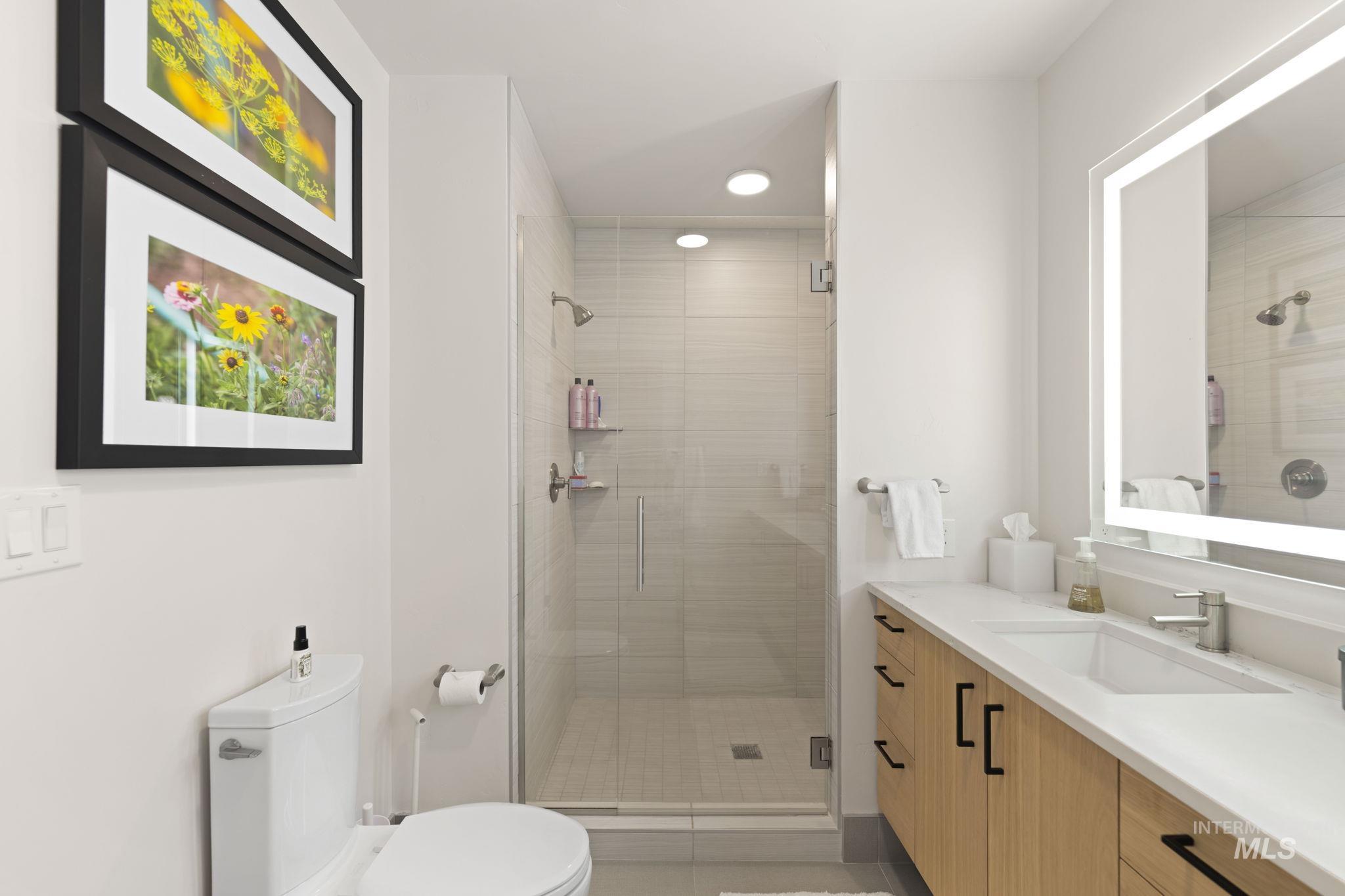 Full bathroom with vanity, a shower stall, and recessed lighting