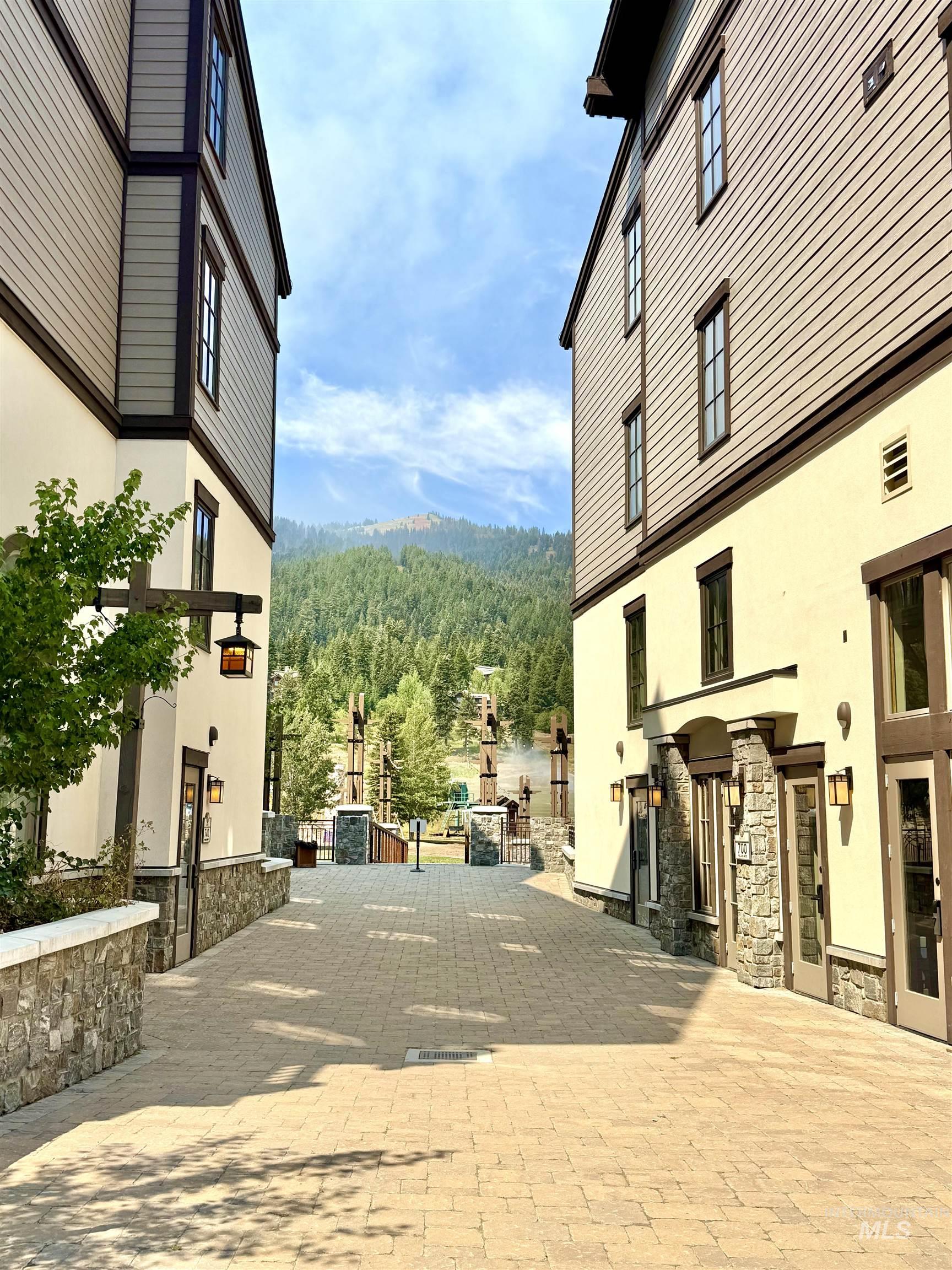 View of decorative driveway with a wooded view