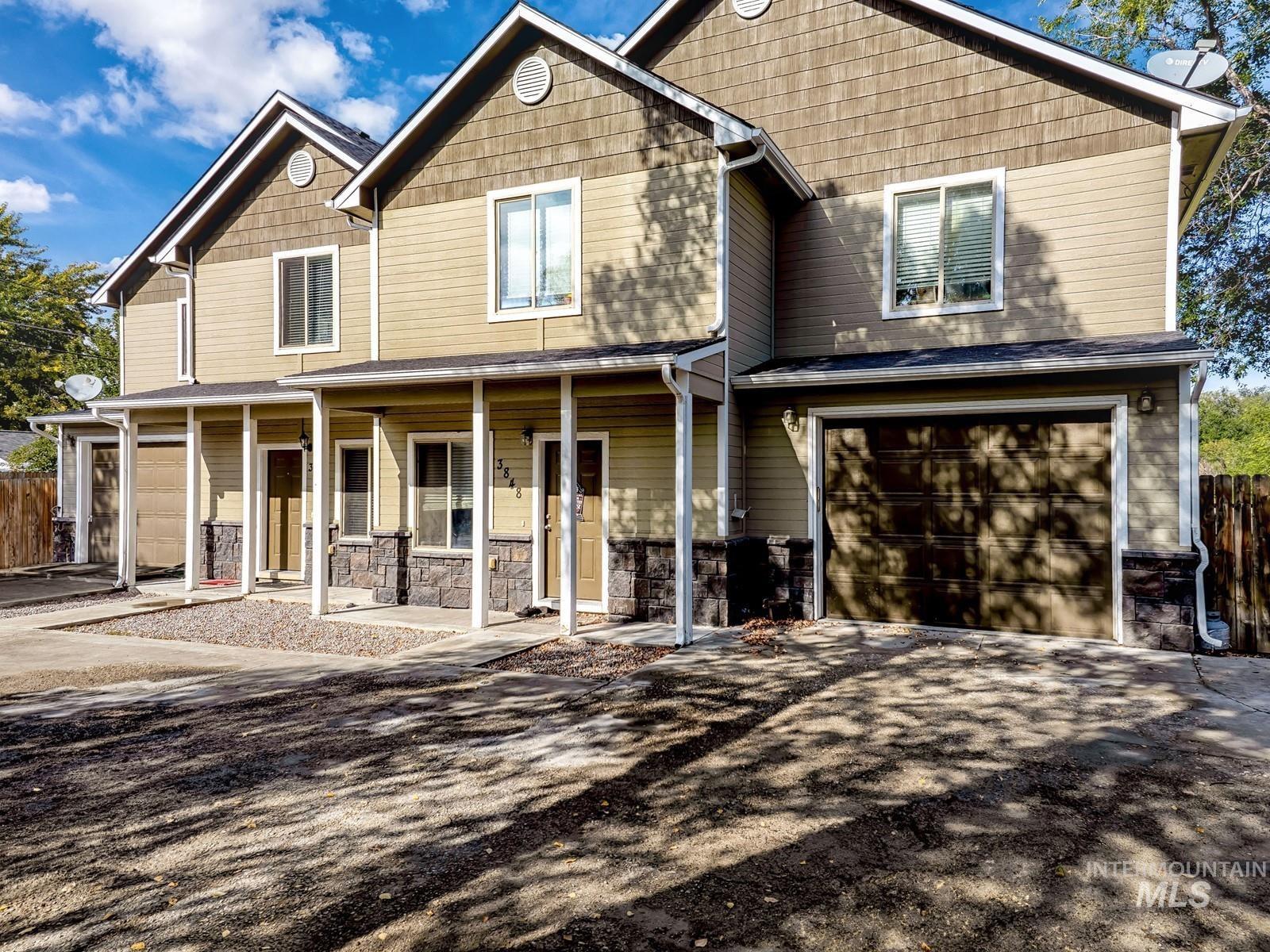 Craftsman-style home featuring a porch, stone siding, a garage, and driveway