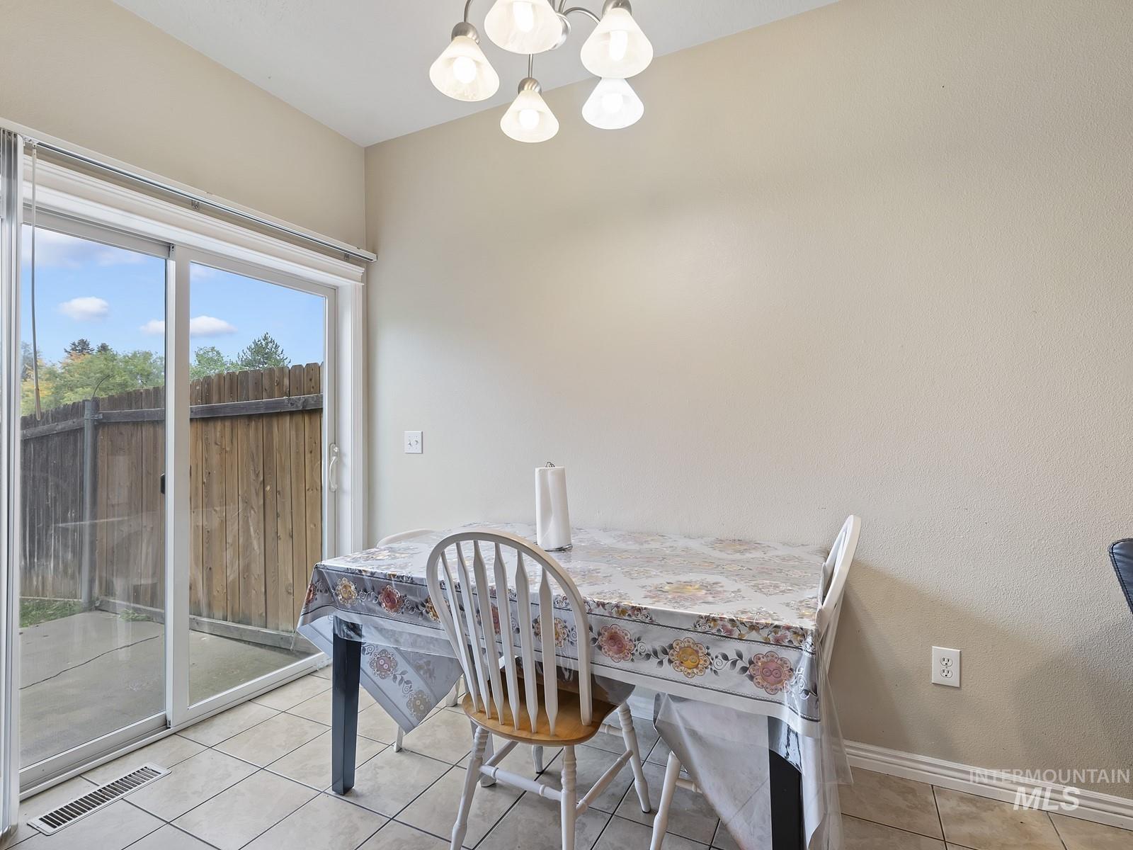 Dining space with a chandelier and light tile patterned flooring