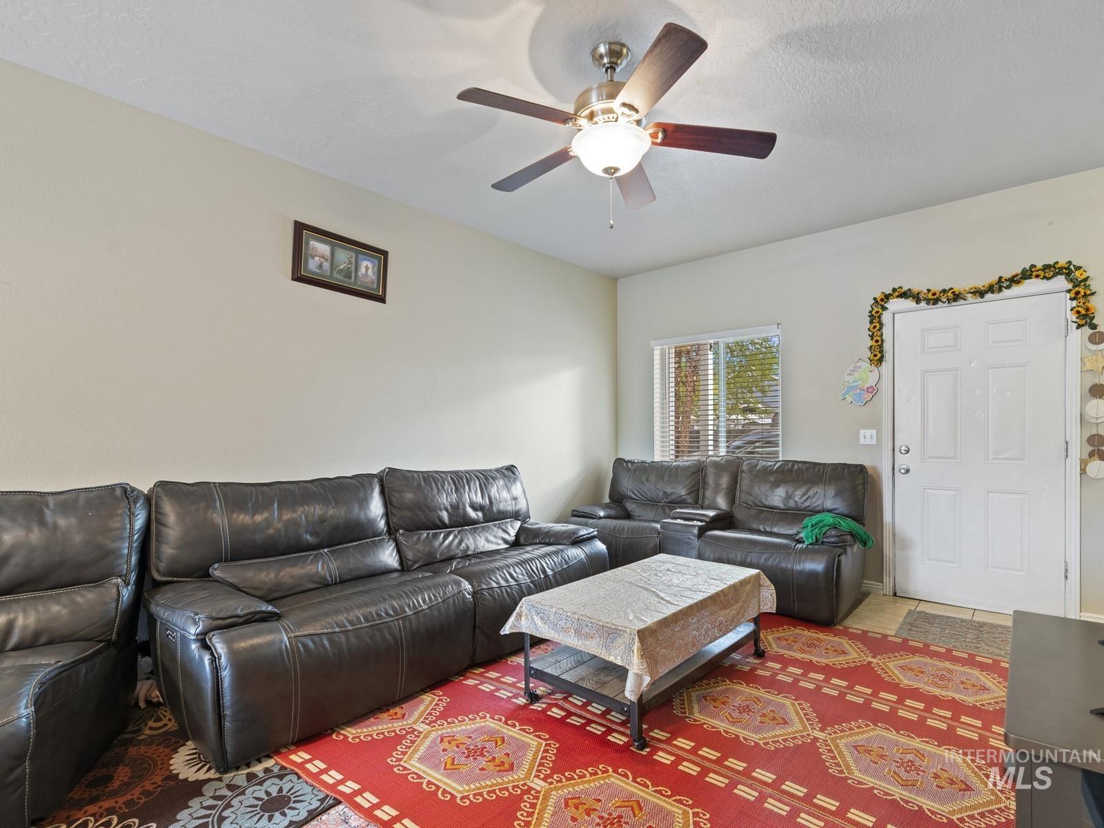Living room featuring a textured ceiling and ceiling fan
