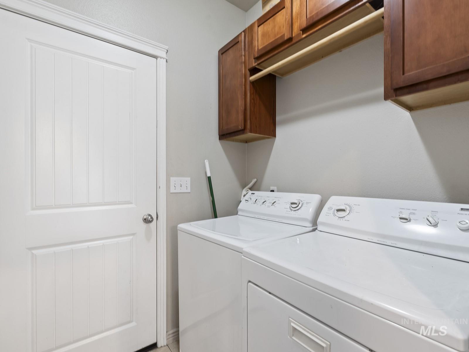 Laundry room featuring washing machine and dryer and cabinet space