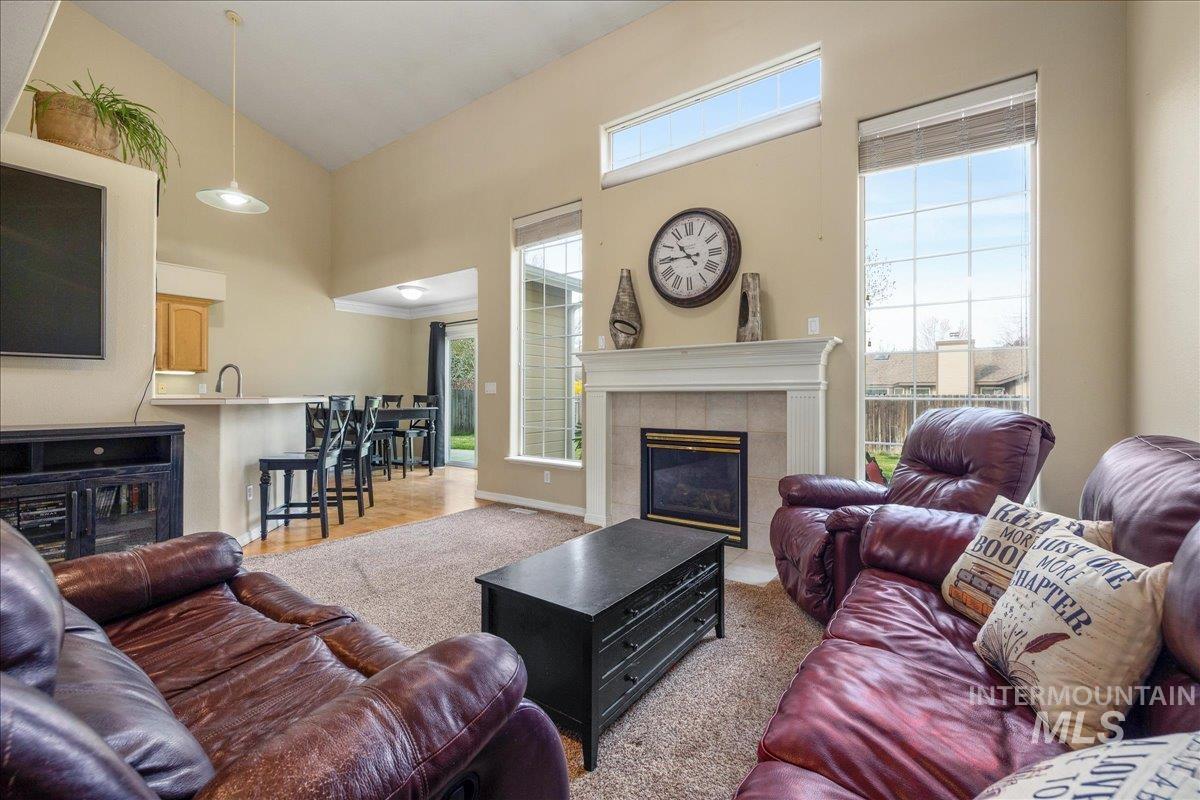 Living area with a tiled fireplace and lofted ceiling