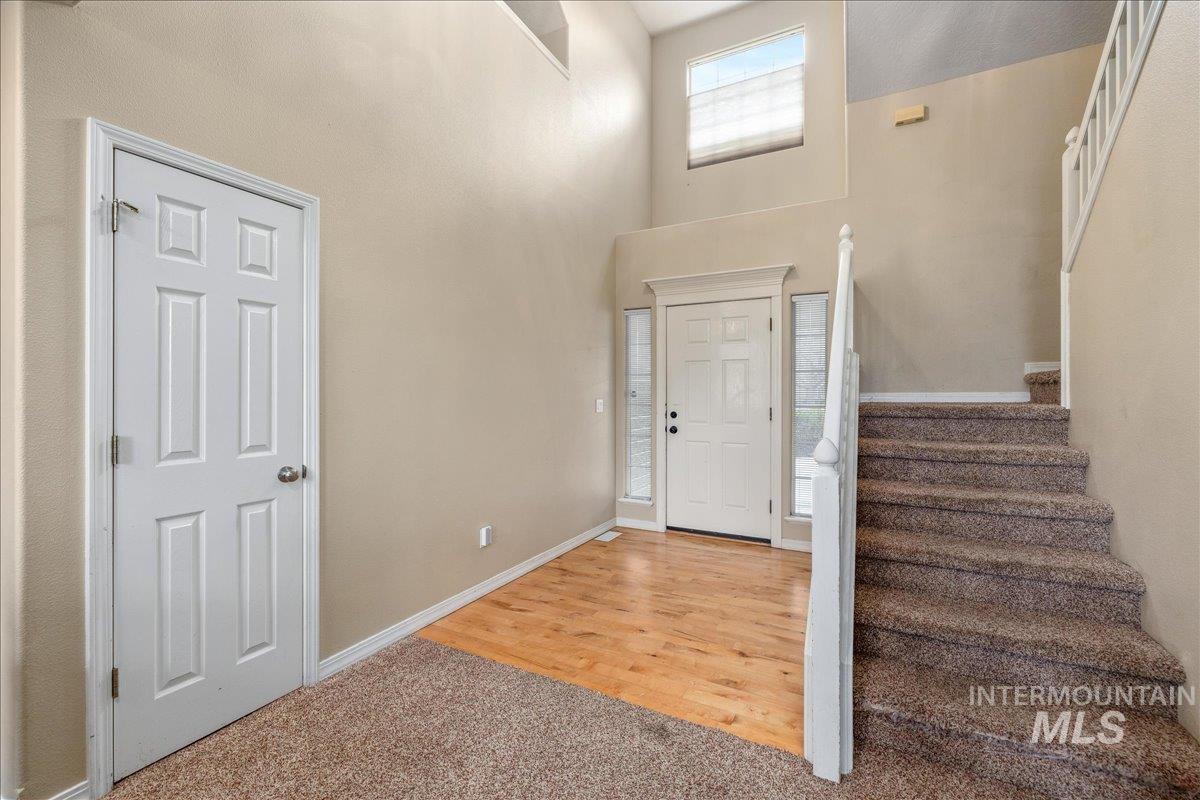 Entryway featuring a high ceiling and light carpet