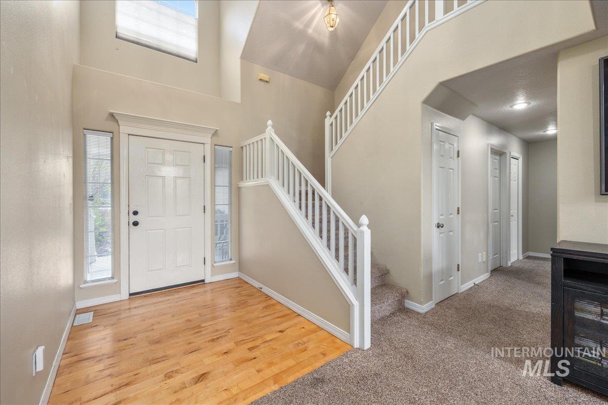 Entrance foyer with light wood finished floors and a high ceiling