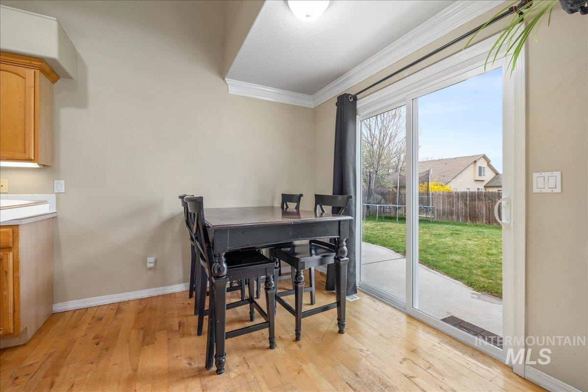 Dining area featuring ornamental molding and light wood-type flooring