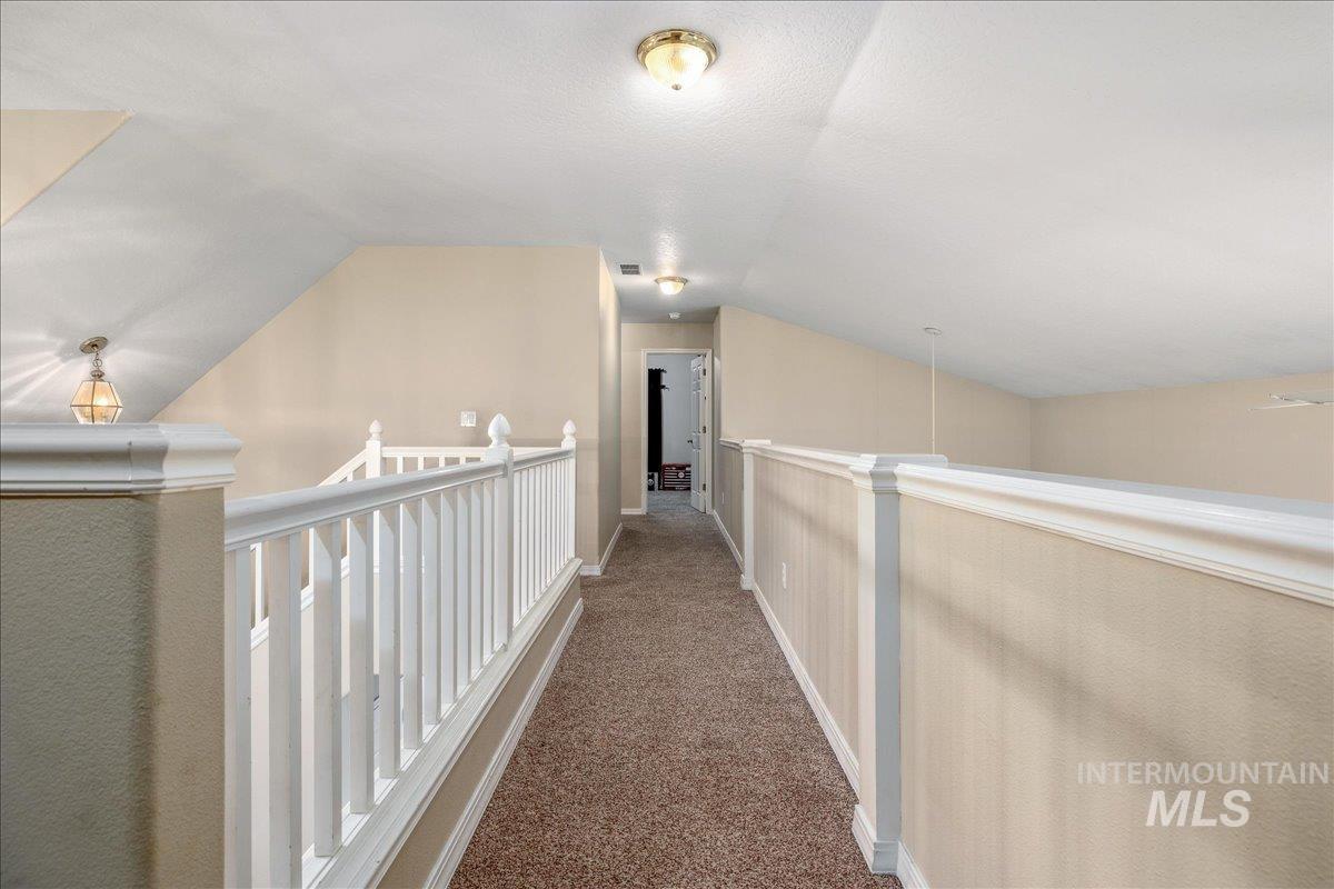 Hall featuring carpet floors and an upstairs landing