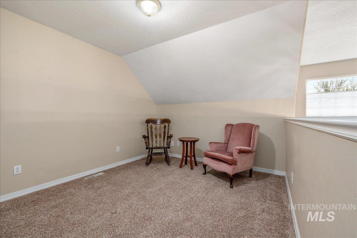 Living area featuring light colored carpet and baseboards