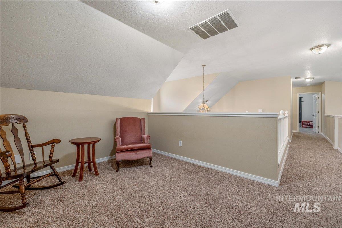 Living area with light colored carpet and baseboards