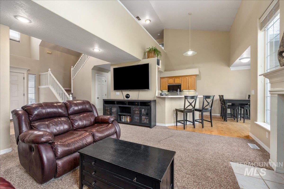 Living room featuring light colored carpet and vaulted ceiling