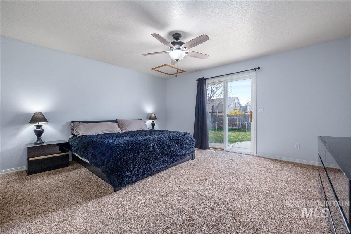 Bedroom with access to outside, light colored carpet, a ceiling fan, and a textured ceiling