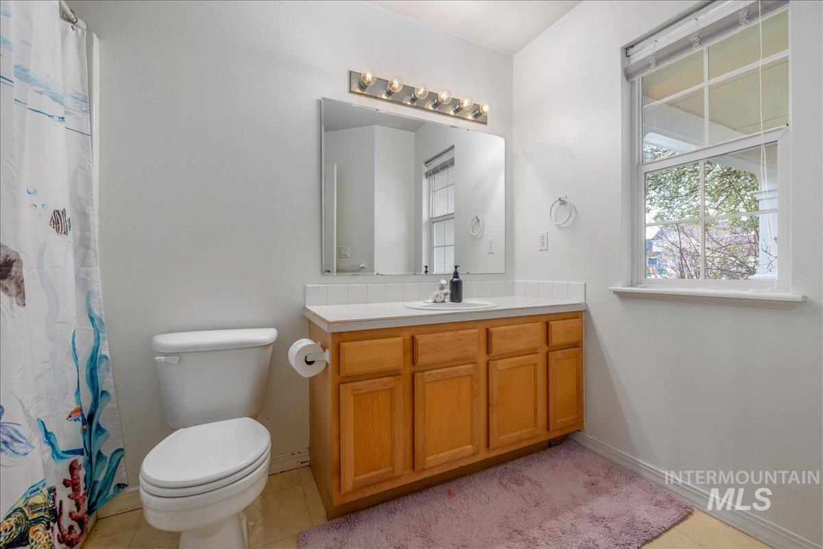 Bathroom with vanity, curtained shower, and light tile patterned floors