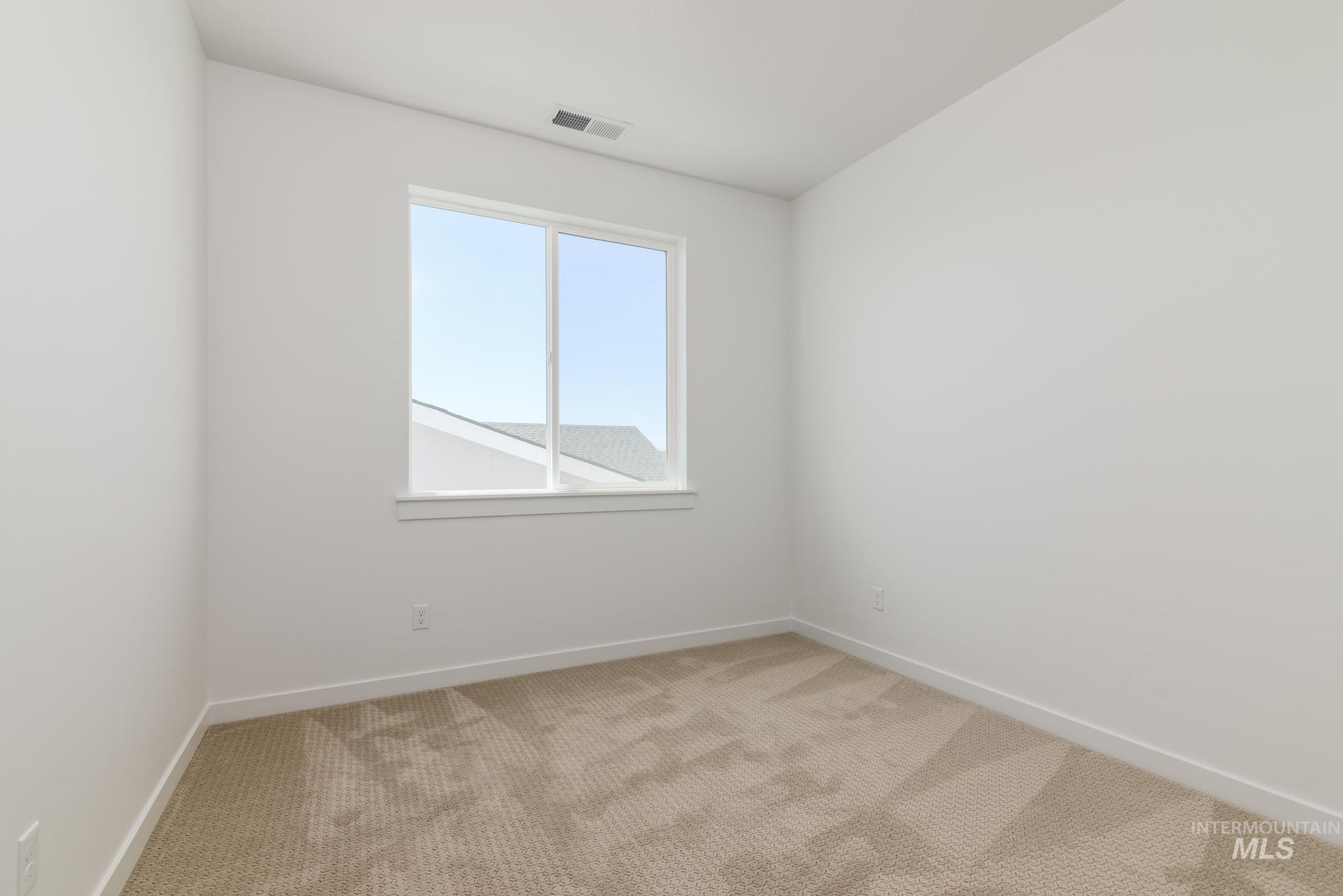 Carpeted empty room featuring baseboards