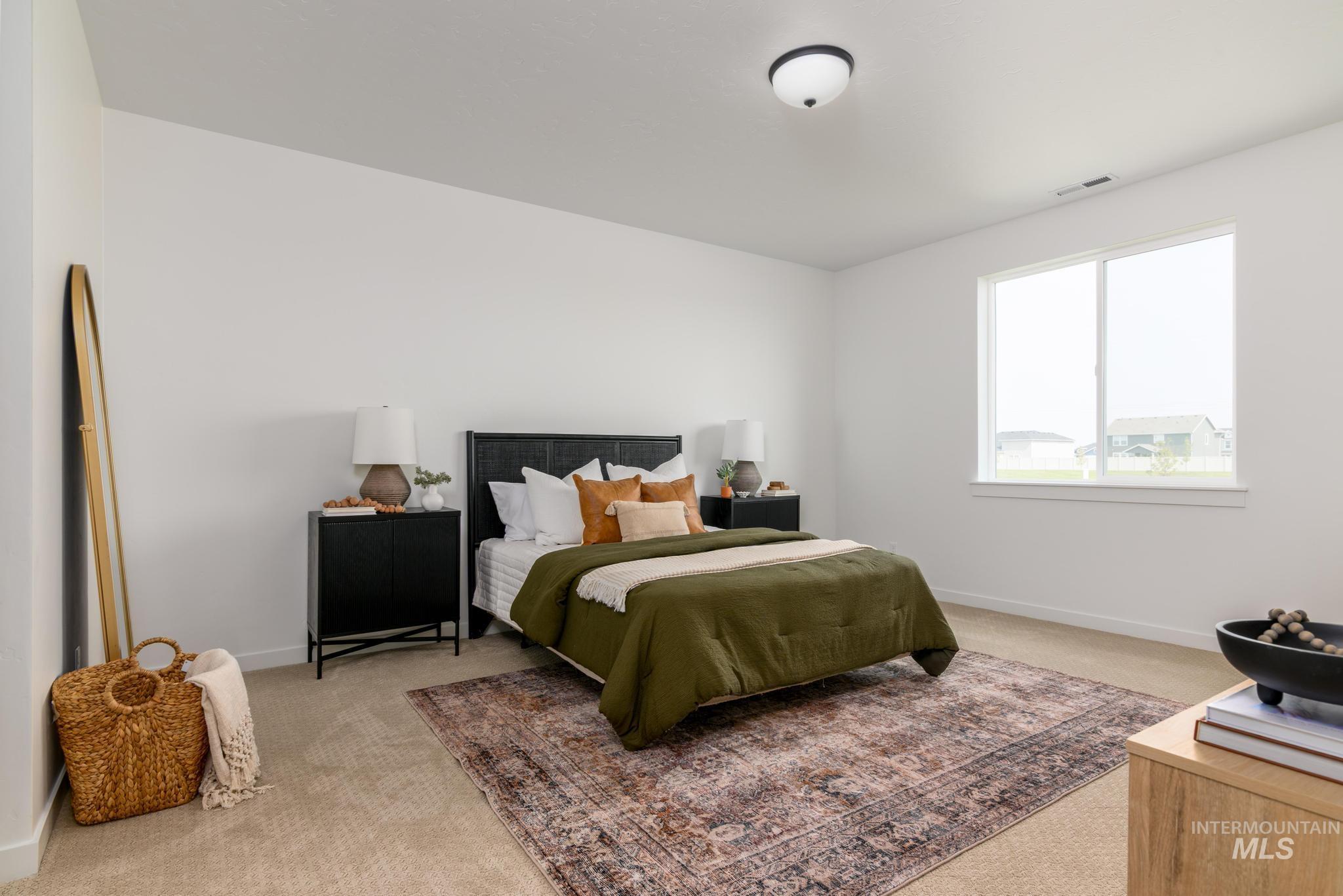 Bedroom featuring light carpet and baseboards