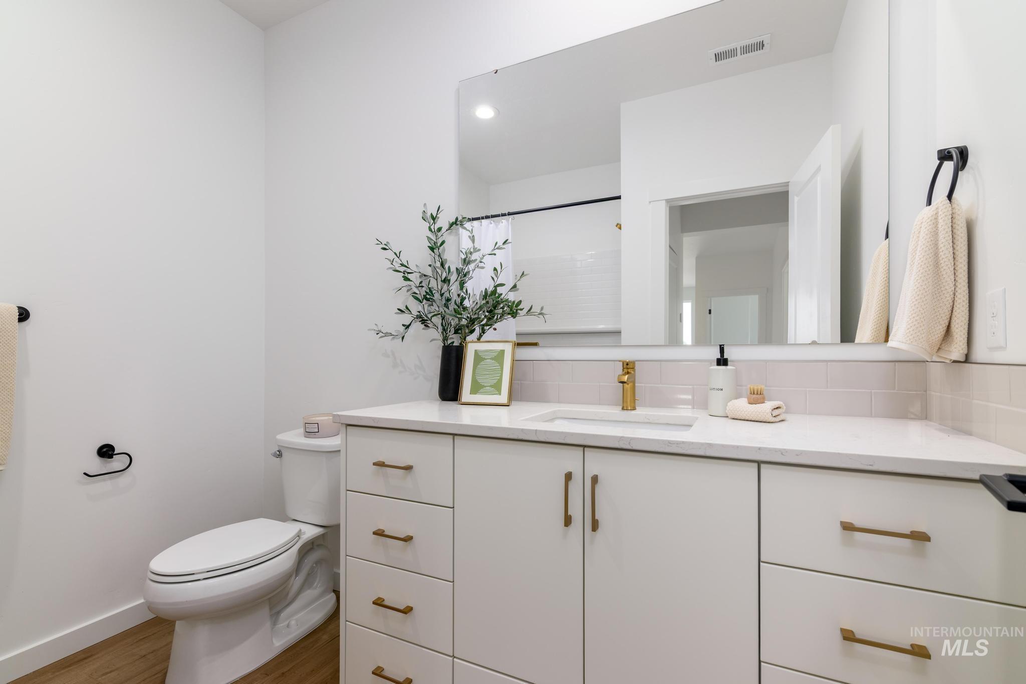 Bathroom featuring vanity, light wood finished floors, a shower with curtain, and recessed lighting