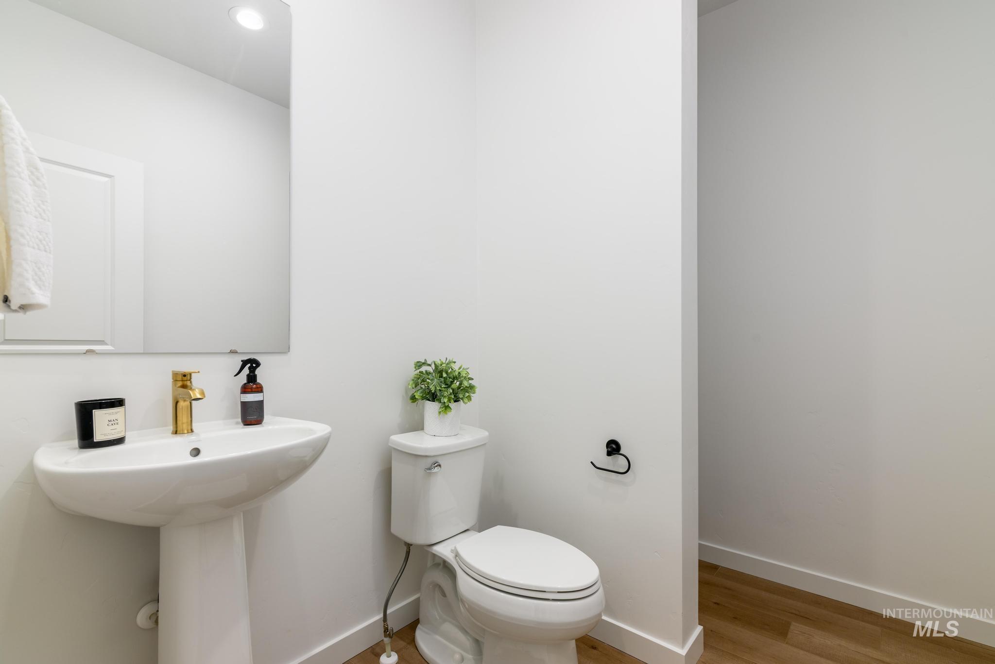 Half bathroom featuring toilet and light wood-style flooring