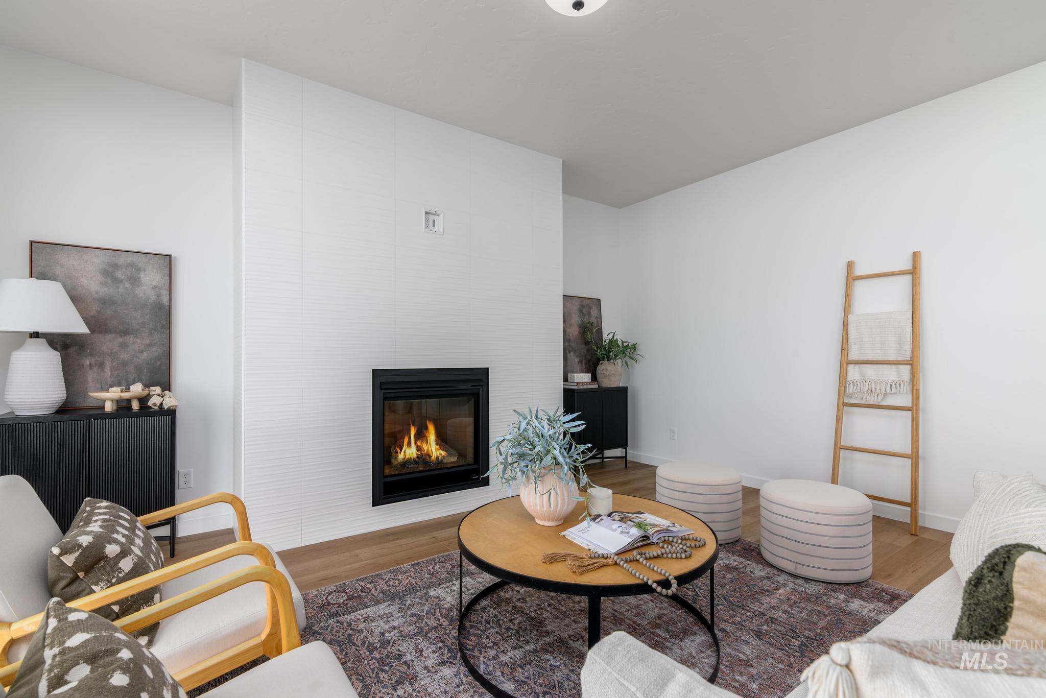 Living area with a large fireplace and wood finished floors