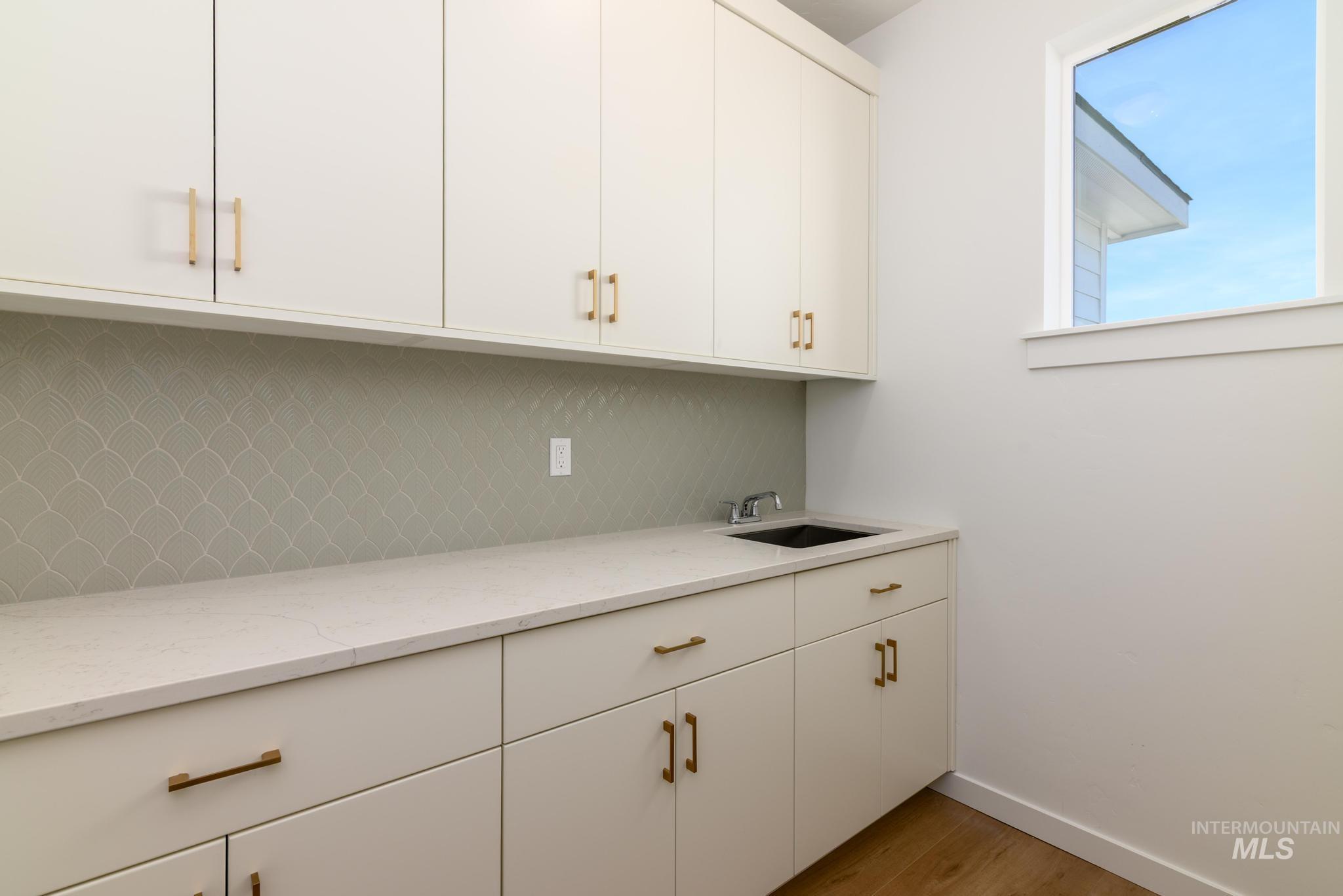 Bar featuring backsplash and wood finished floors