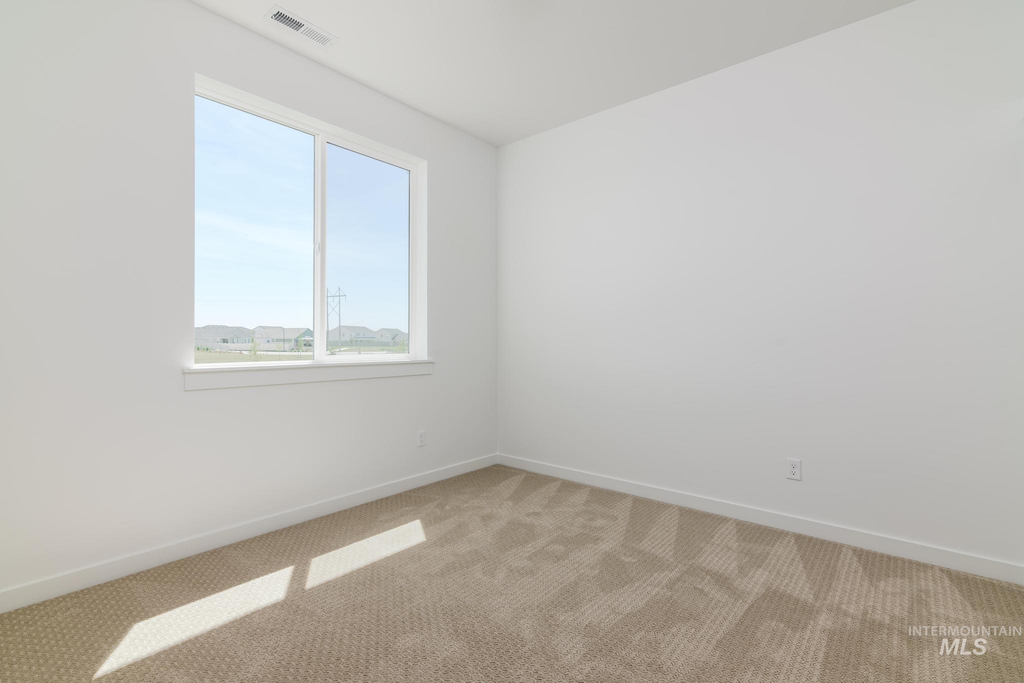 Unfurnished room featuring light colored carpet and baseboards