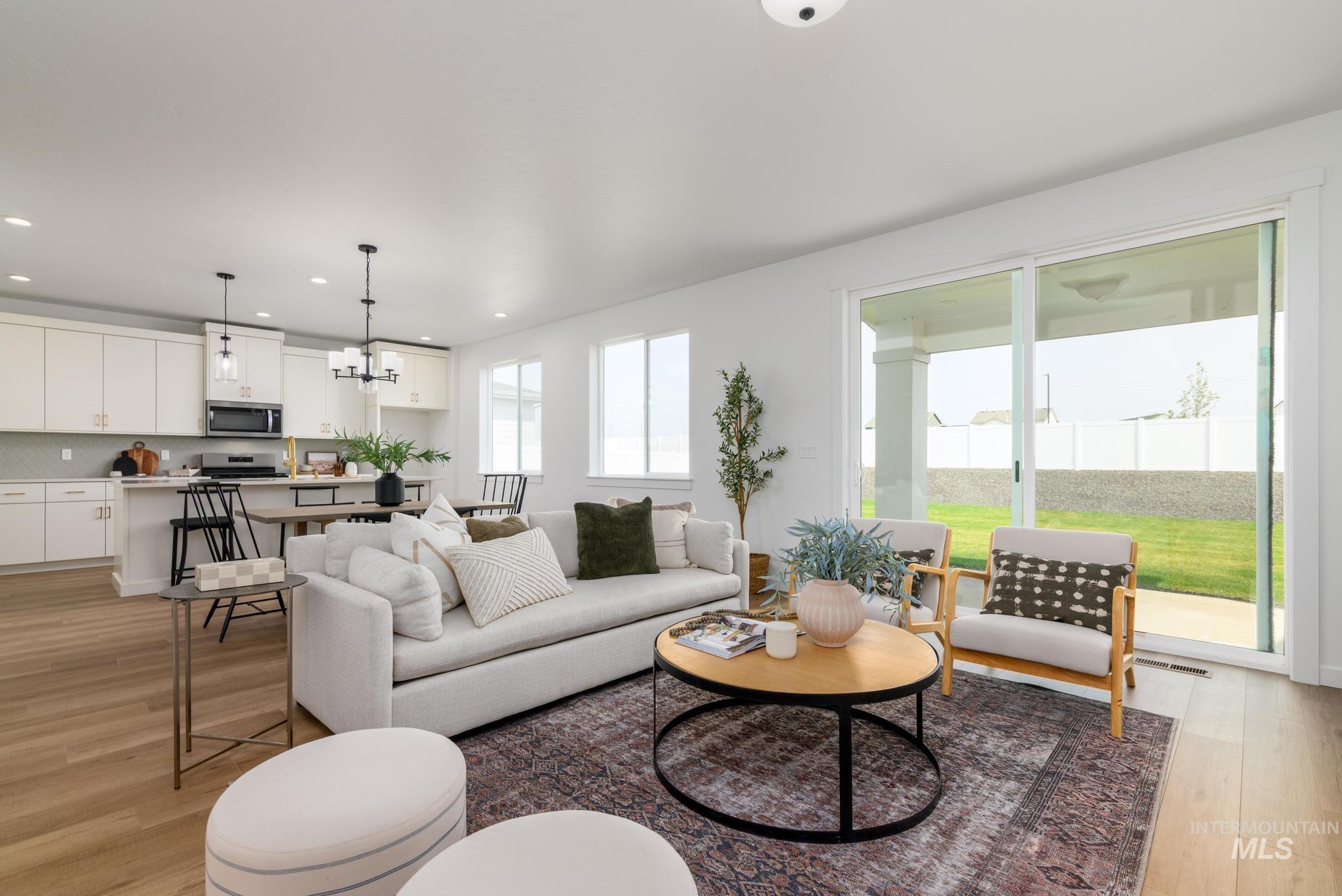 Living room featuring light wood-style floors, a chandelier, and recessed lighting