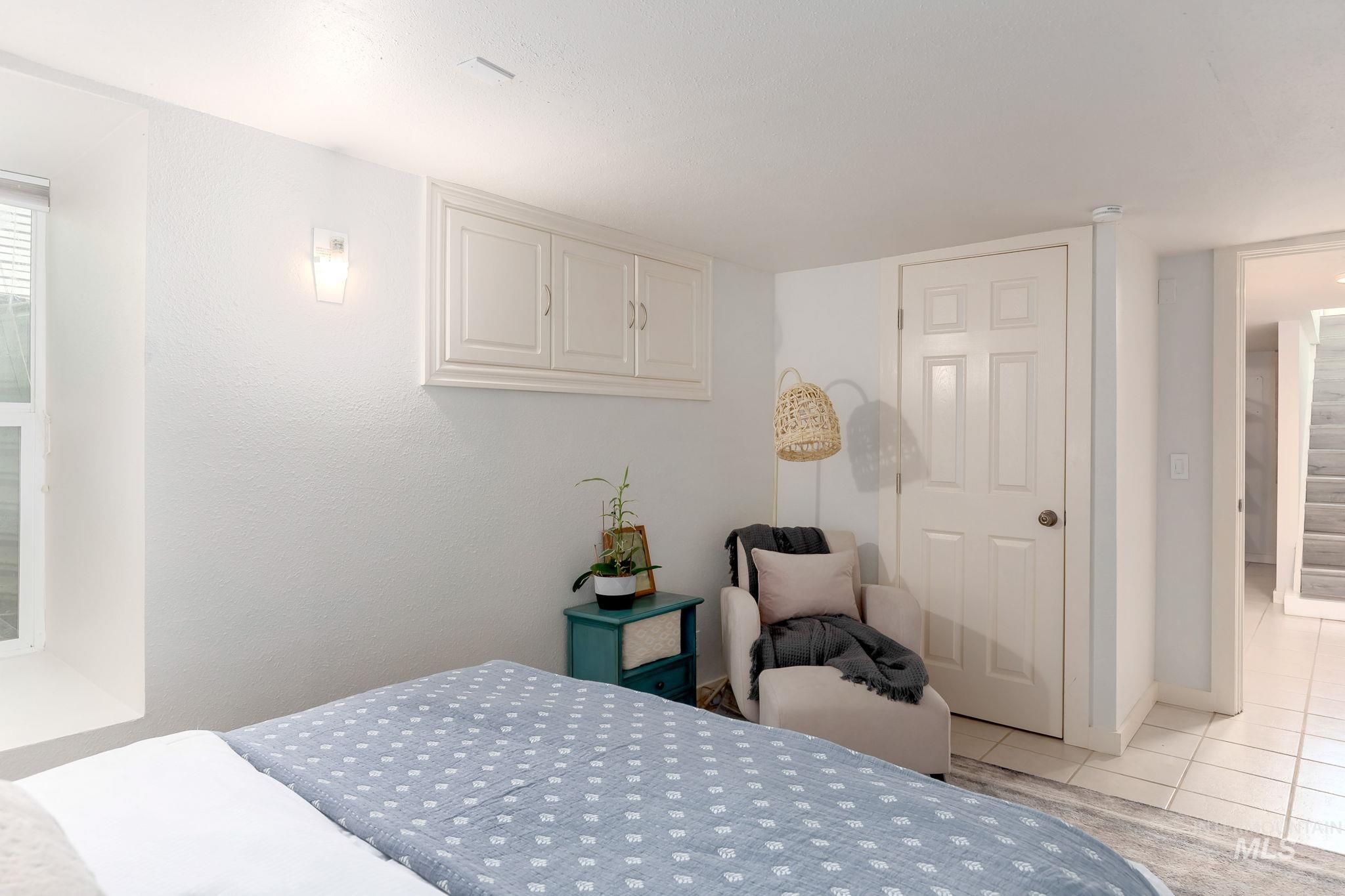 Bedroom featuring light tile patterned floors and baseboards