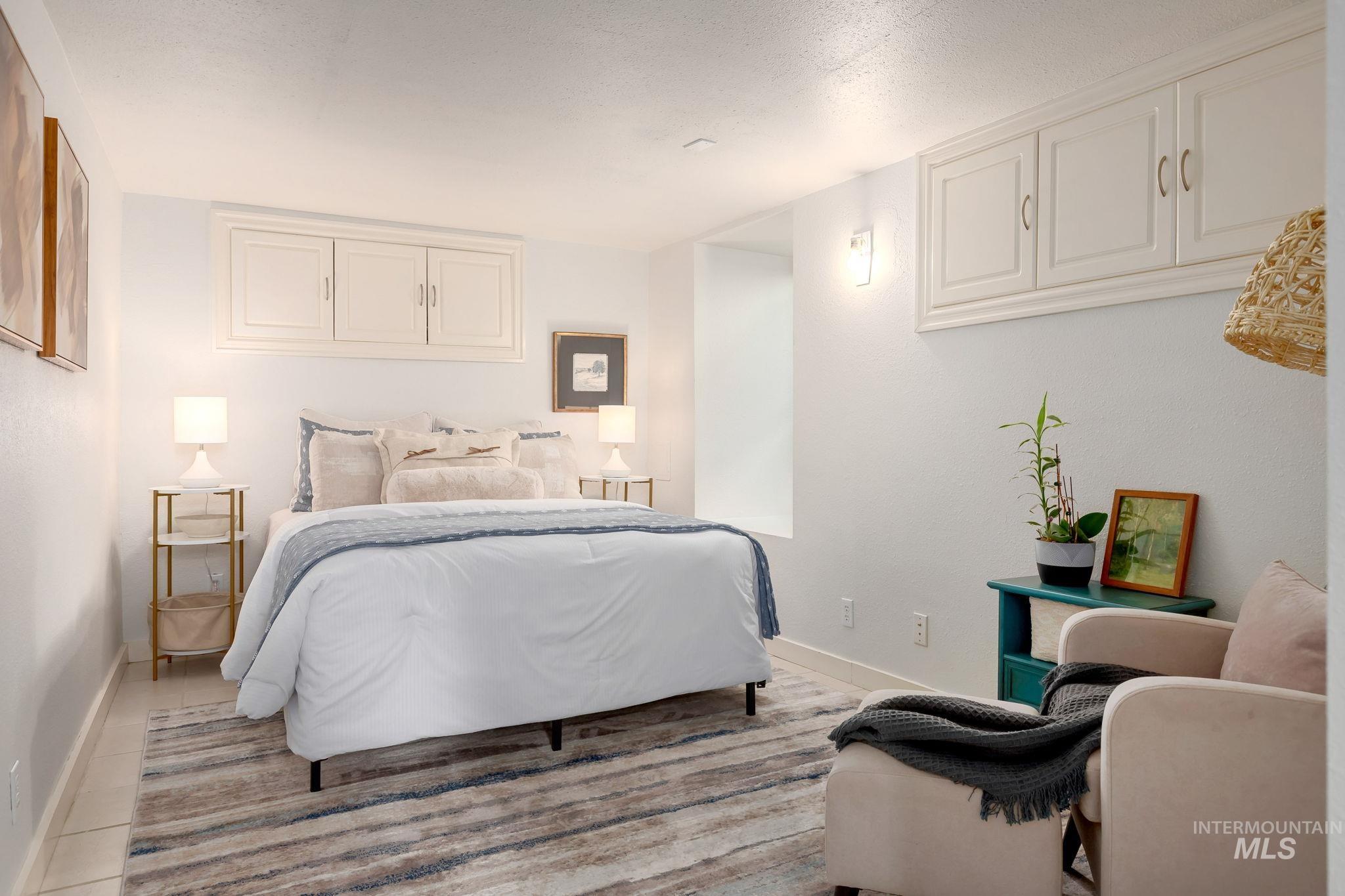 Bedroom with a textured ceiling and light tile patterned flooring