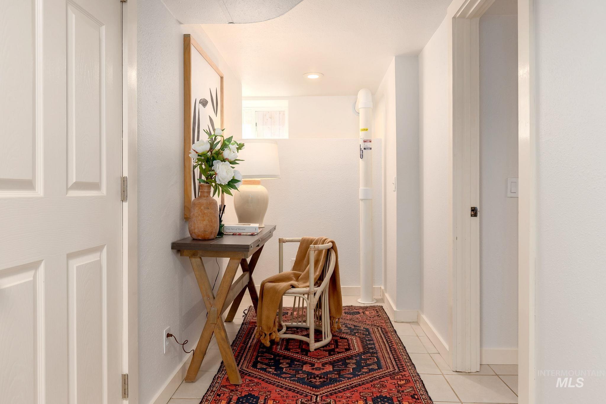 Corridor featuring light tile patterned flooring and baseboards