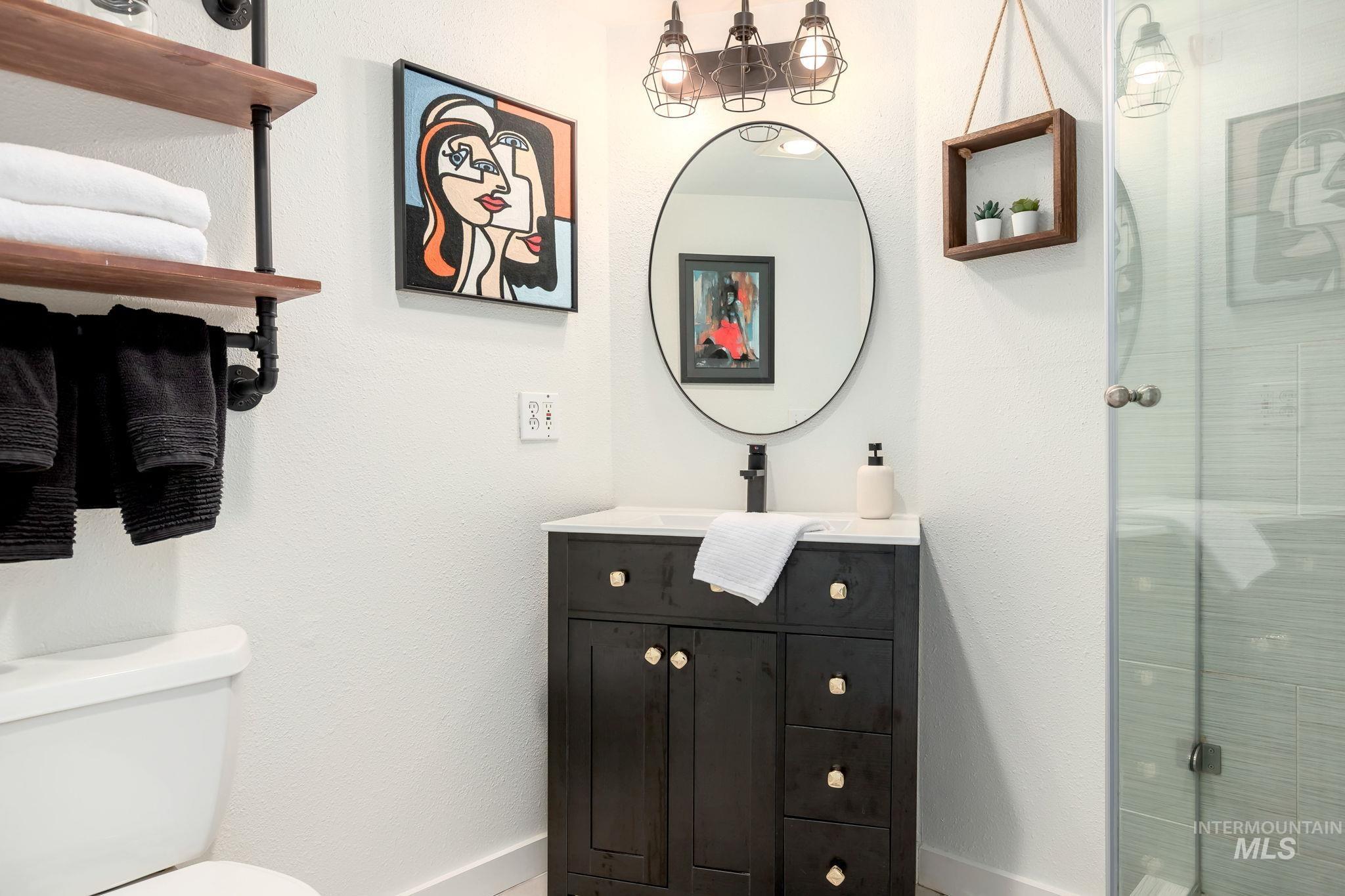 Full bathroom with a stall shower, vanity, and a textured wall