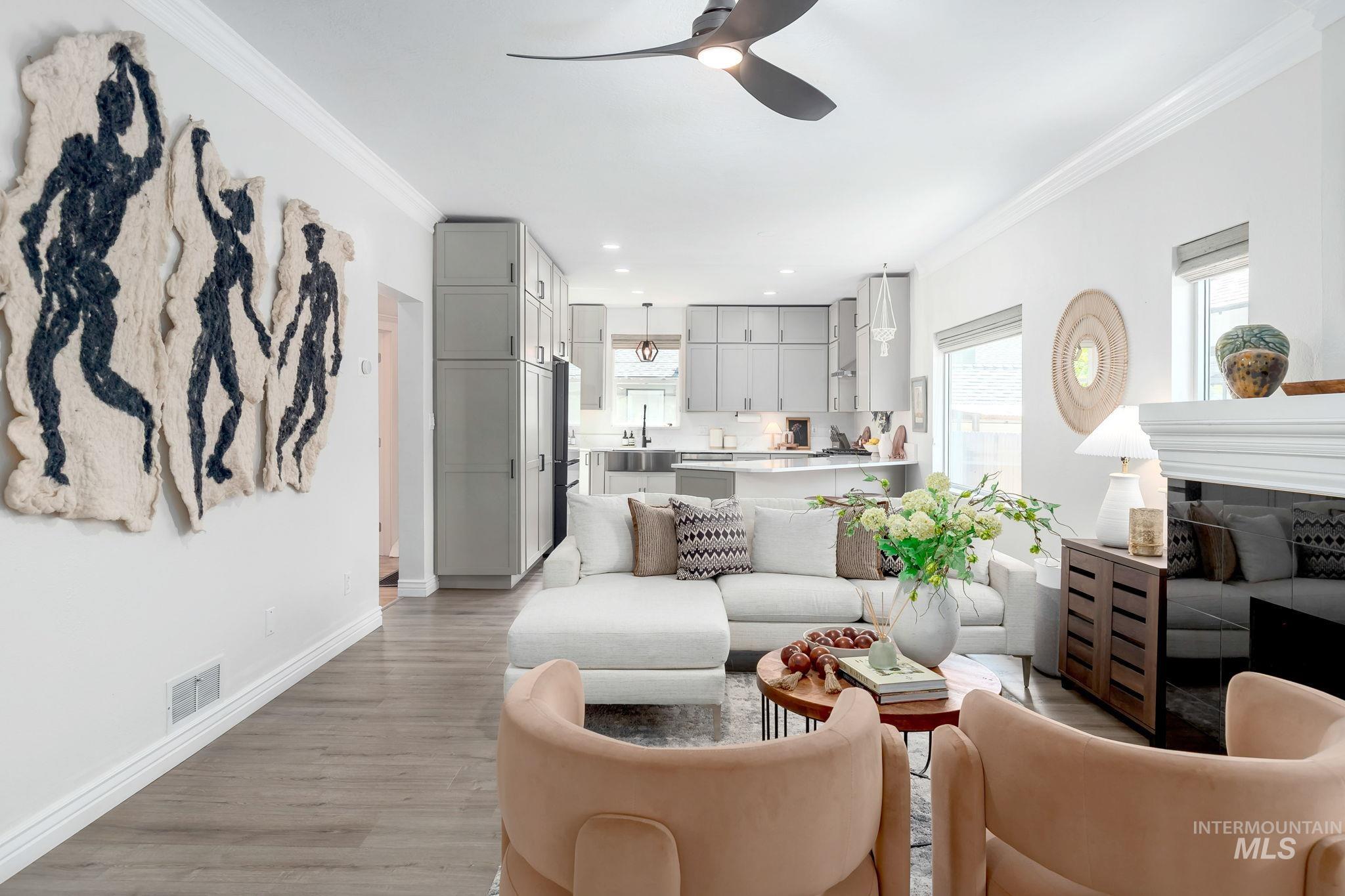 Living room featuring crown molding, healthy amount of natural light, a ceiling fan, light wood finished floors, and recessed lighting