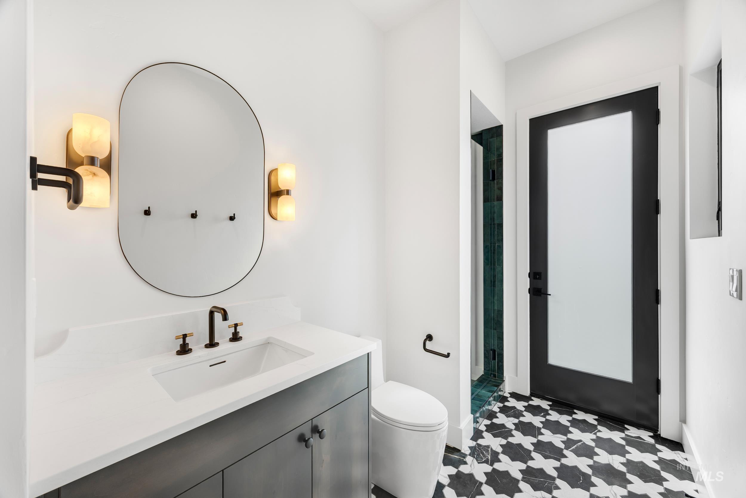 Bathroom featuring a stall shower, vanity, and light flooring