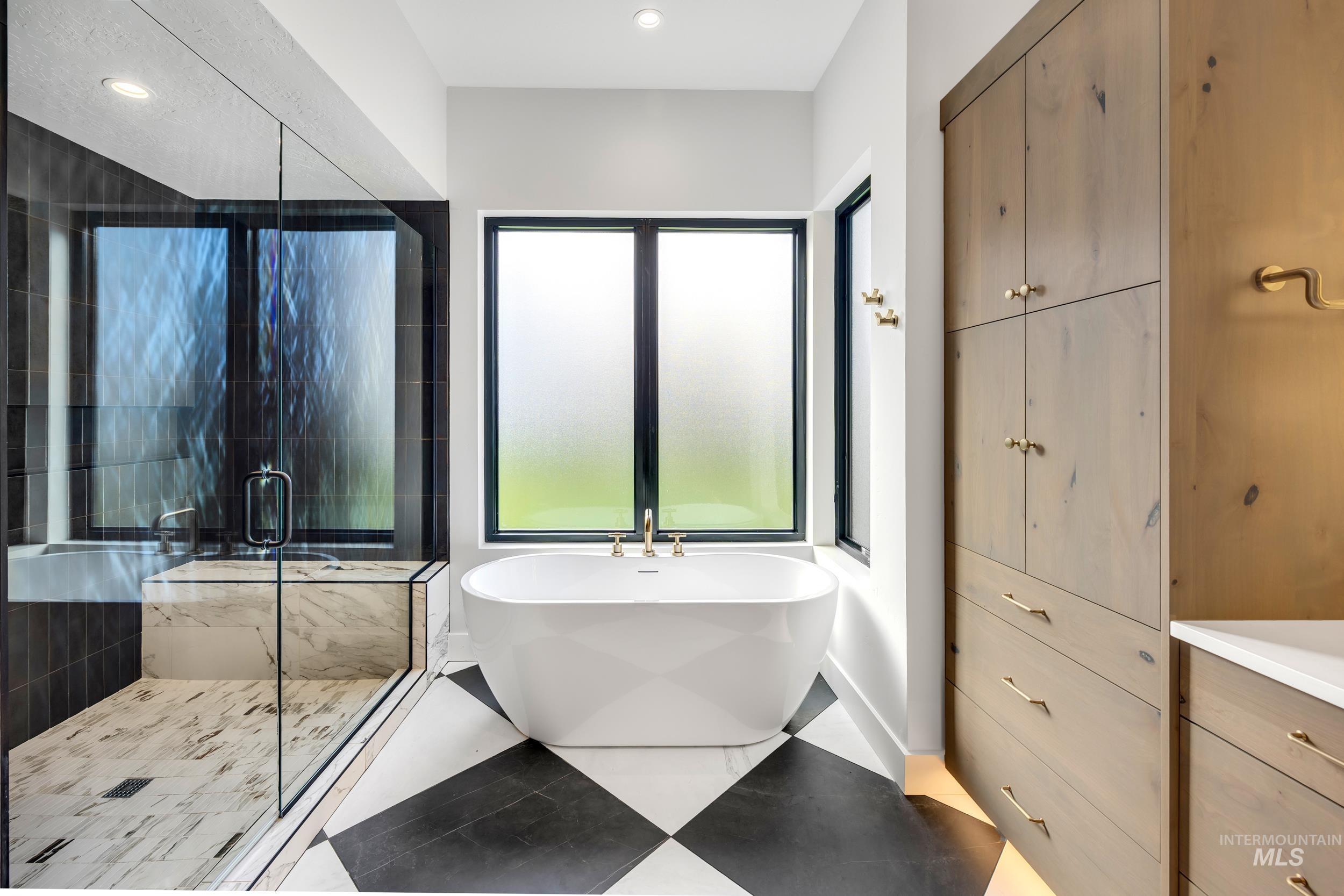 Full bathroom featuring a freestanding tub, a stall shower, vanity, and recessed lighting