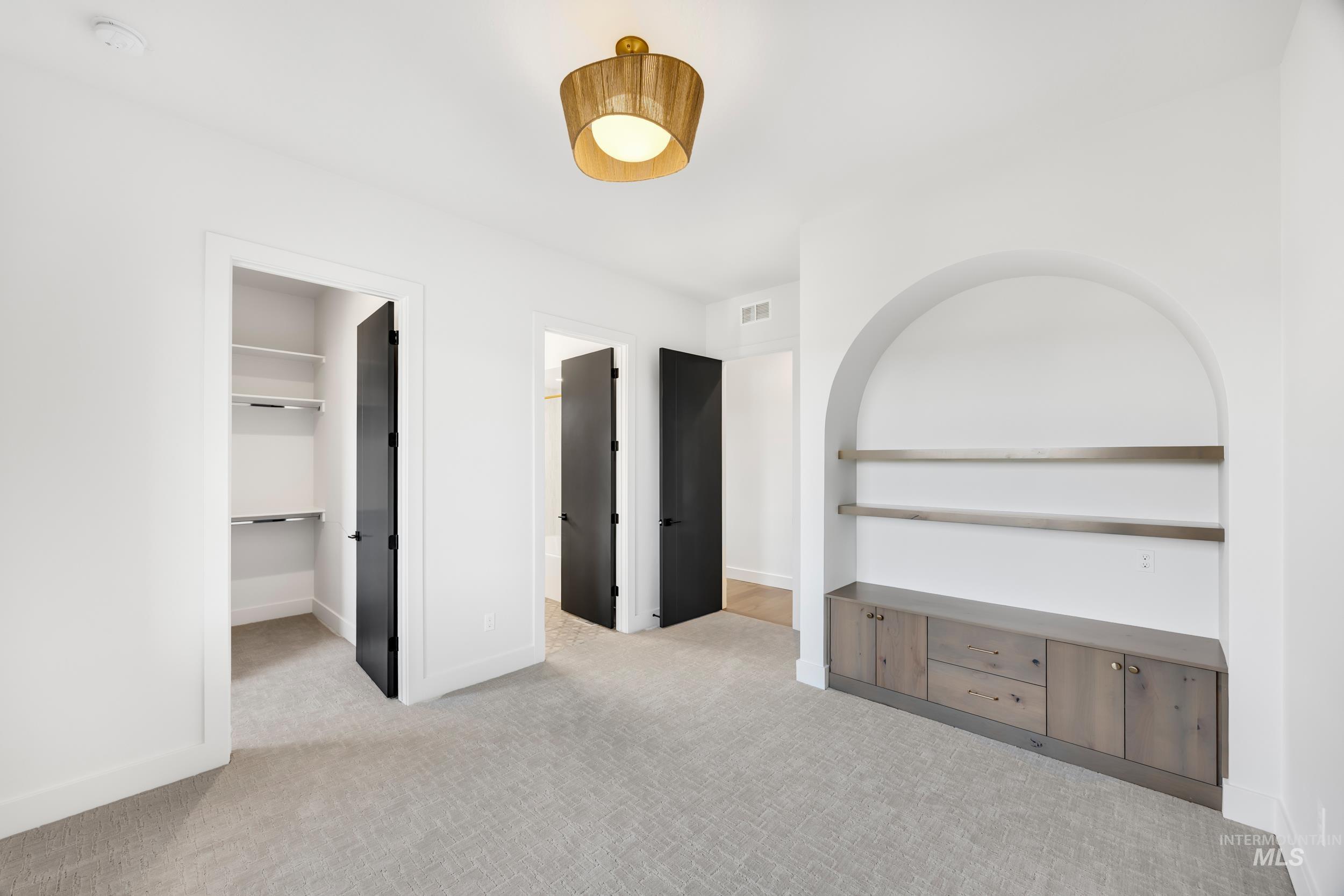 Unfurnished bedroom featuring light carpet, a spacious closet, and connected bathroom