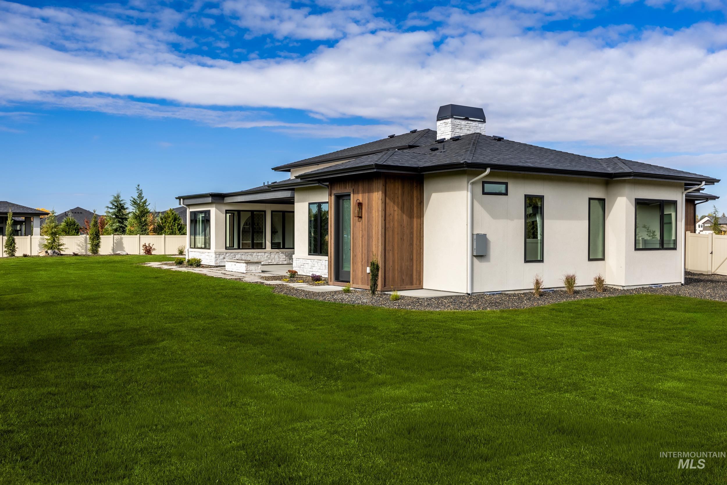 Rear view of property featuring a chimney, a sunroom, and stucco siding