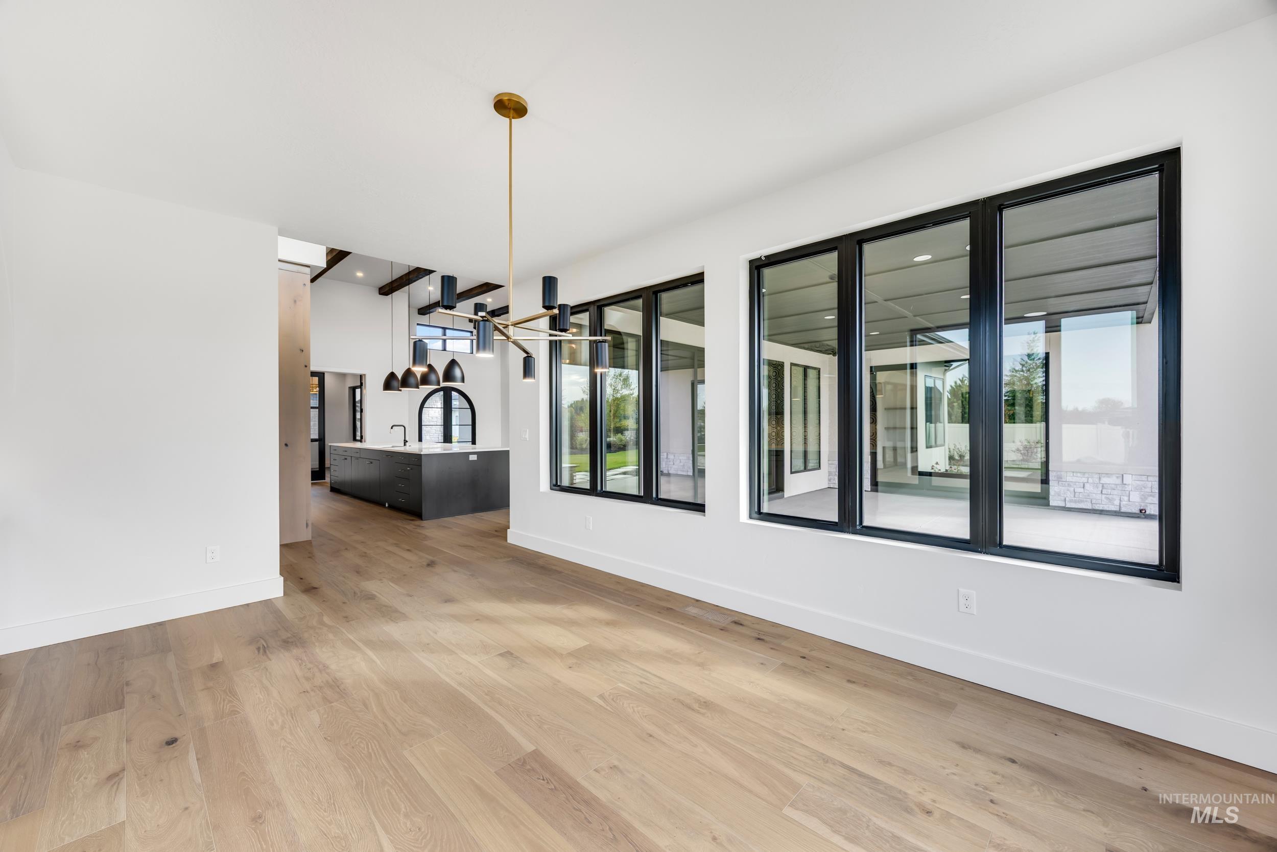 Unfurnished dining area featuring plenty of natural light, light wood finished floors, and a chandelier