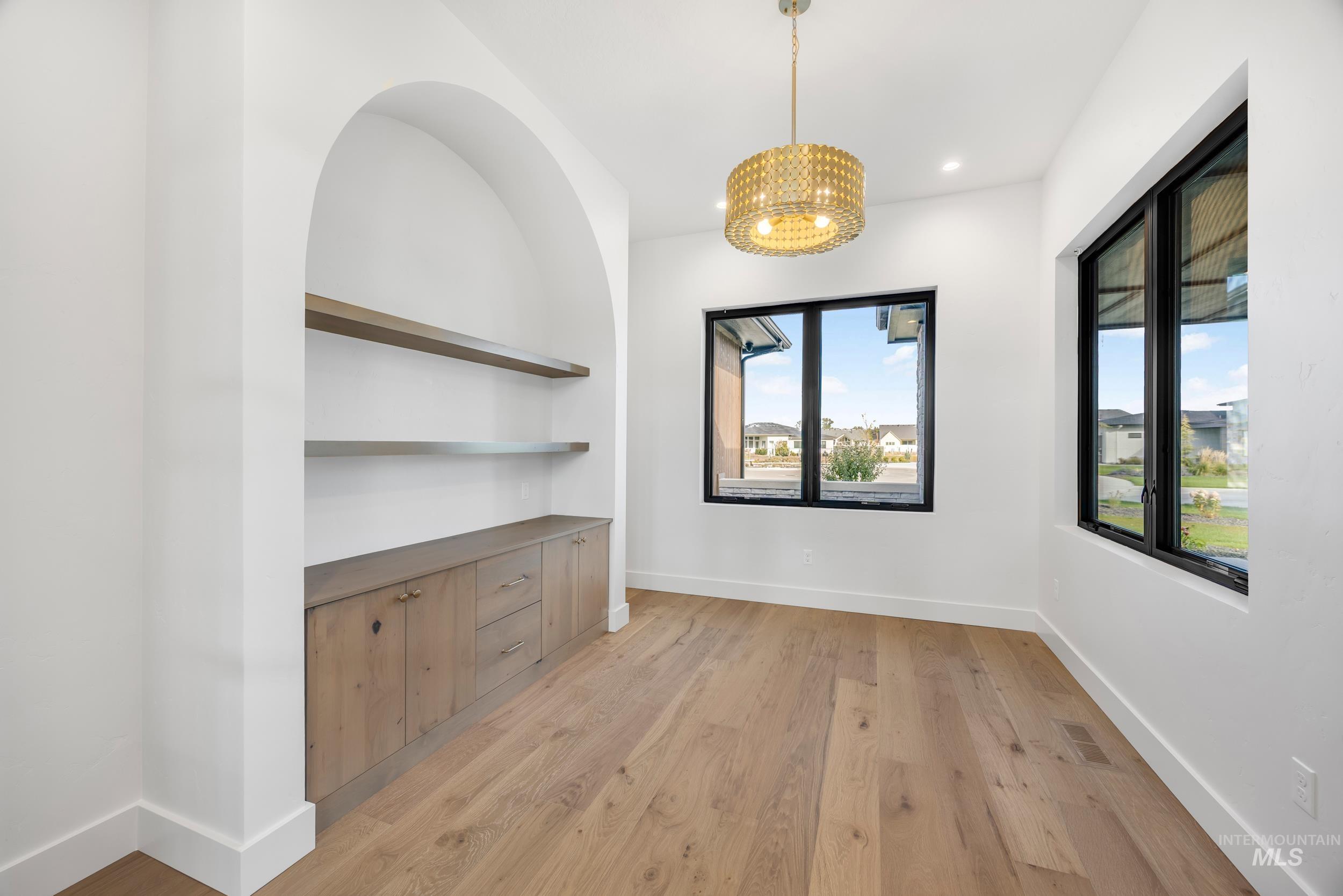 Unfurnished dining area with light wood finished floors, a chandelier, and recessed lighting
