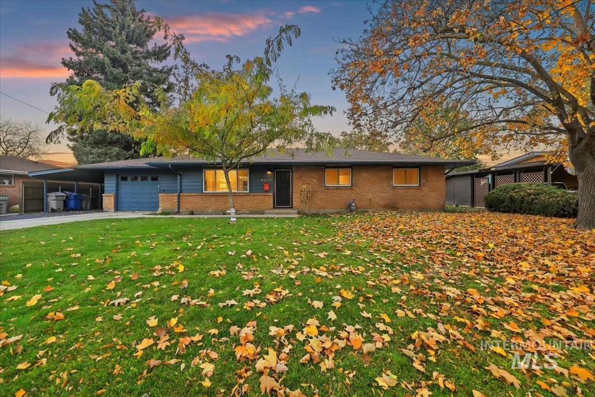 Ranch-style home with brick siding, a garage, driveway, and a front yard