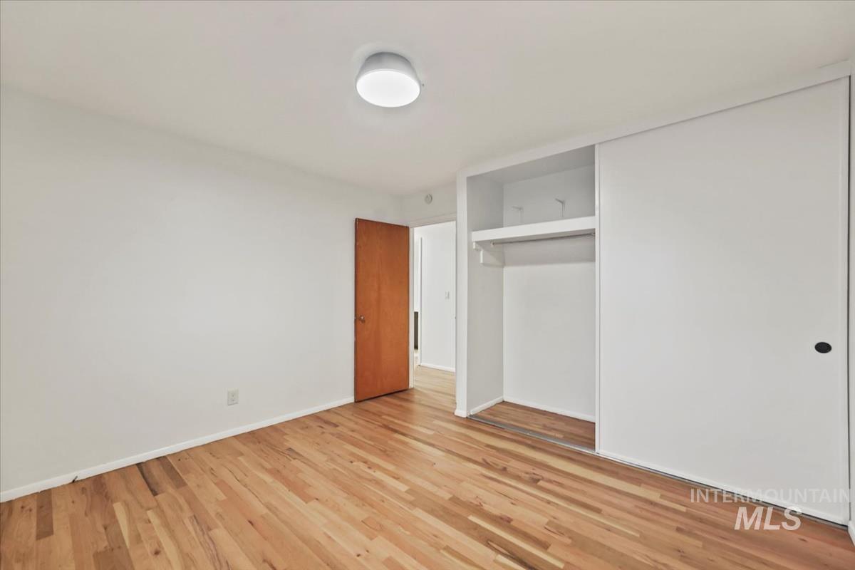 Unfurnished bedroom featuring light wood finished floors and a closet