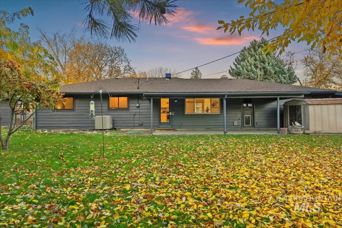 Back of property featuring a patio and a storage unit