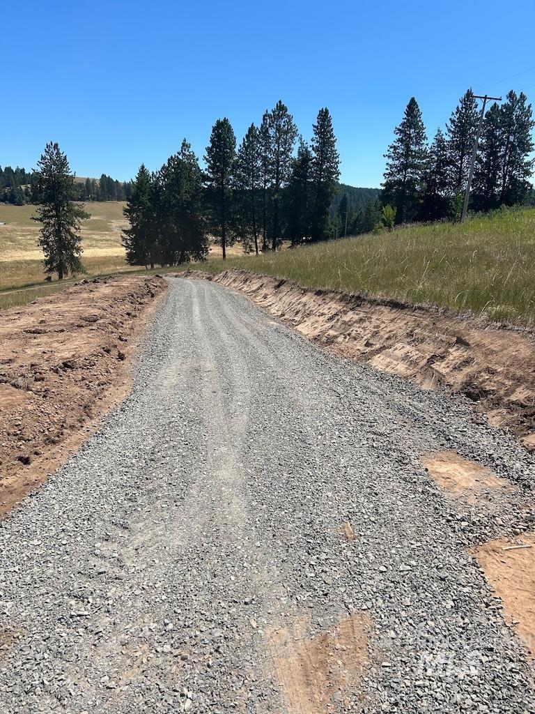 View of dirt / gravel road with a view of rural / pastoral area