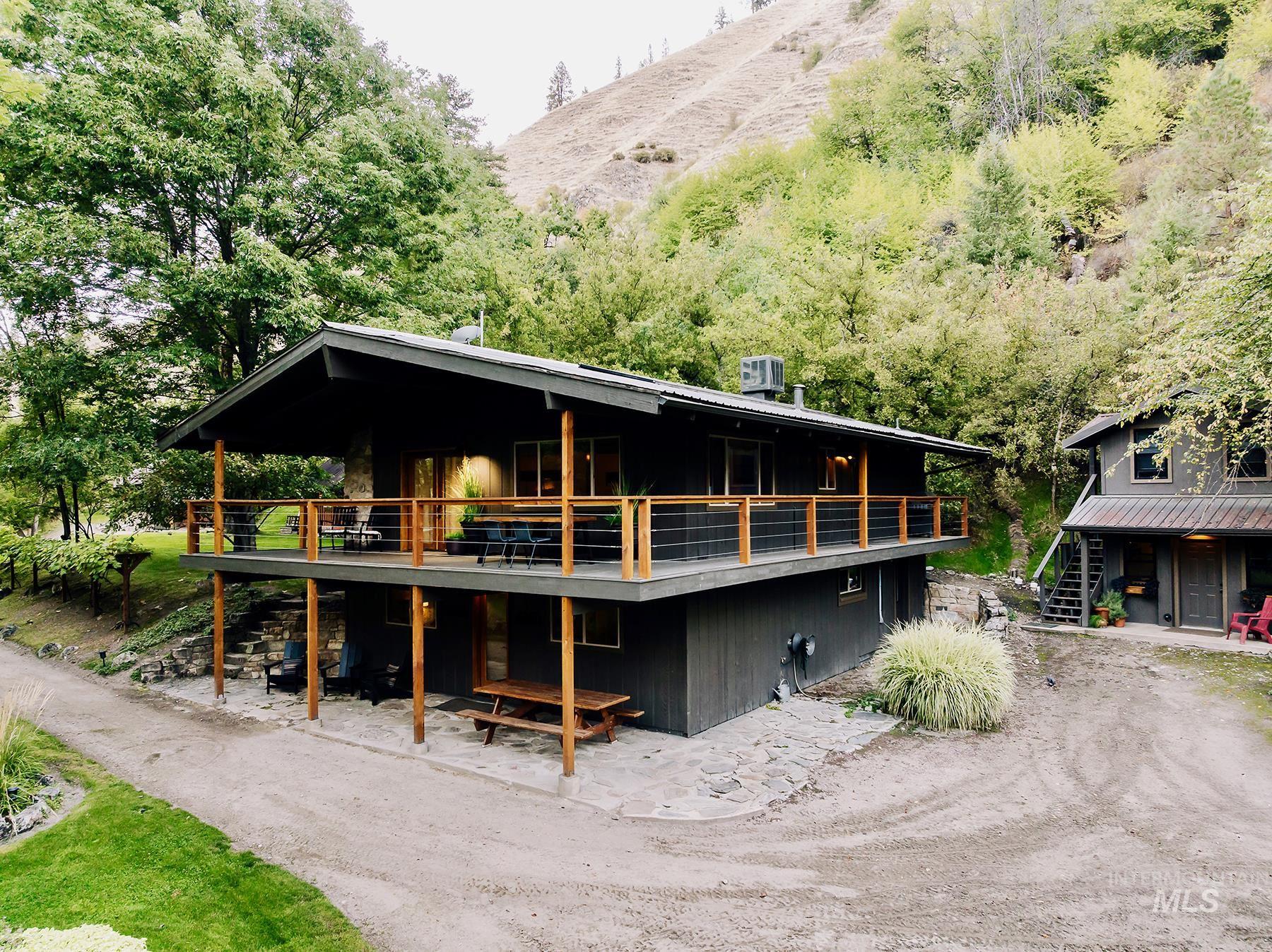 Rear view of property featuring stairs and a wooden deck